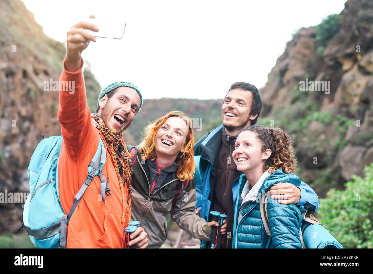 Happy friends faire photo avec l'appareil photo de votre smartphone mobile sur montagne - trekking jeunes millénaire et s'amuser avec les nouvelles tendances en matière de technologie. Banque D'Images