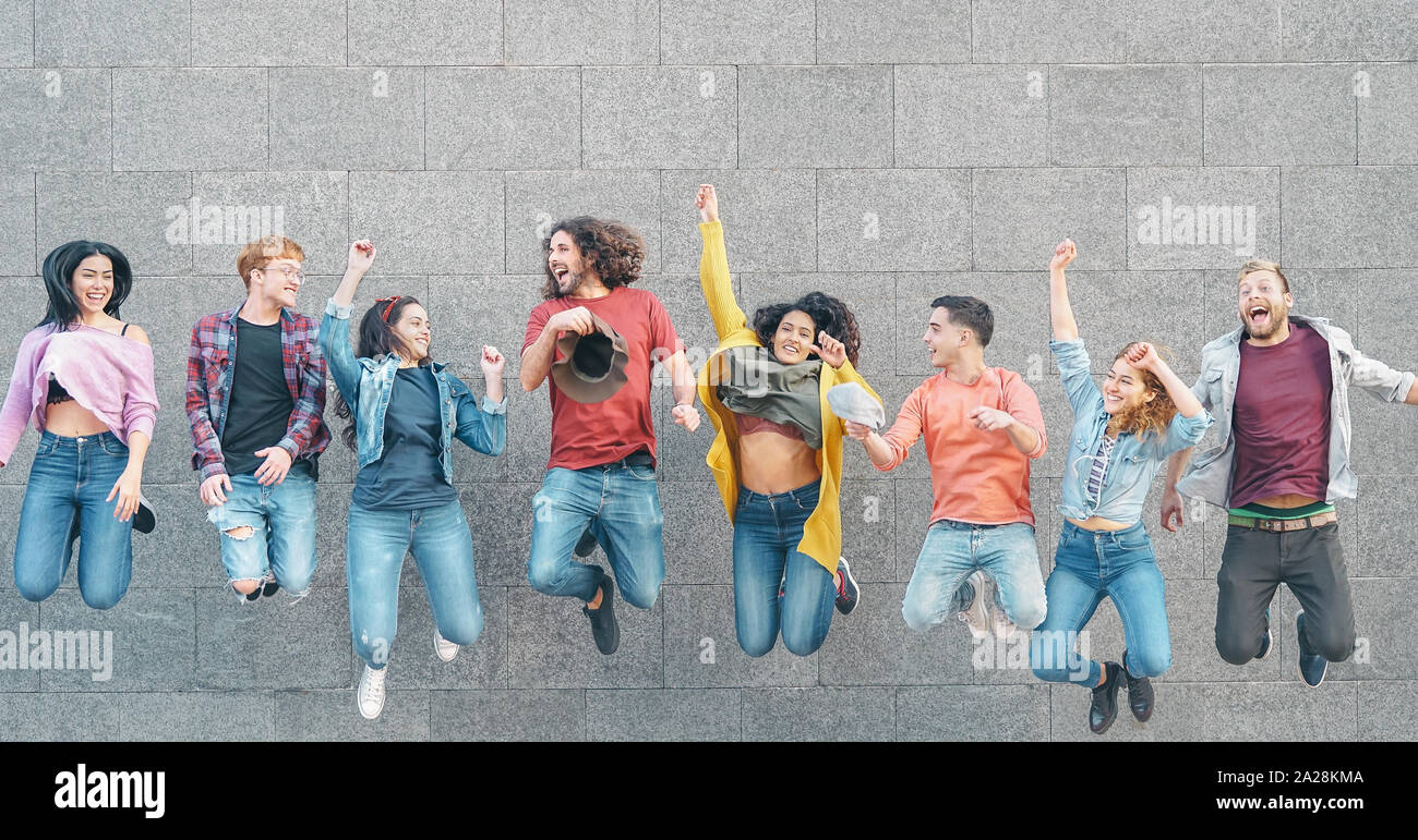 Happy friends jumping ensemble en plein air - jeunes millénaire s'amusant célébrer ensemble en dehors de Banque D'Images