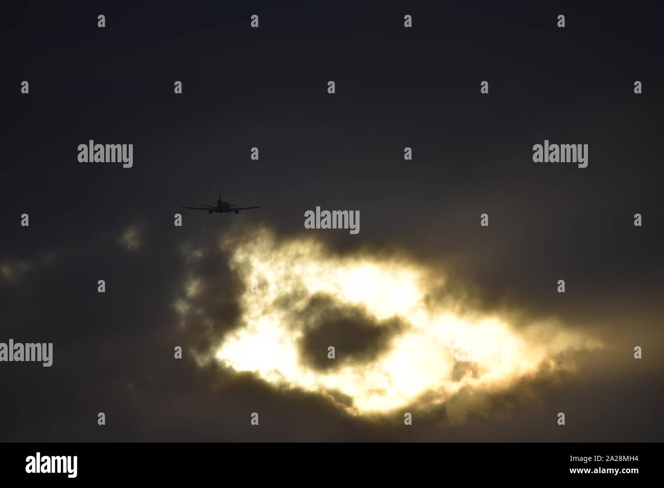 Ciel étrange, ravitaillement américain avion vole vers un étrange trou dans le lumineux nuages noirs. Banque D'Images