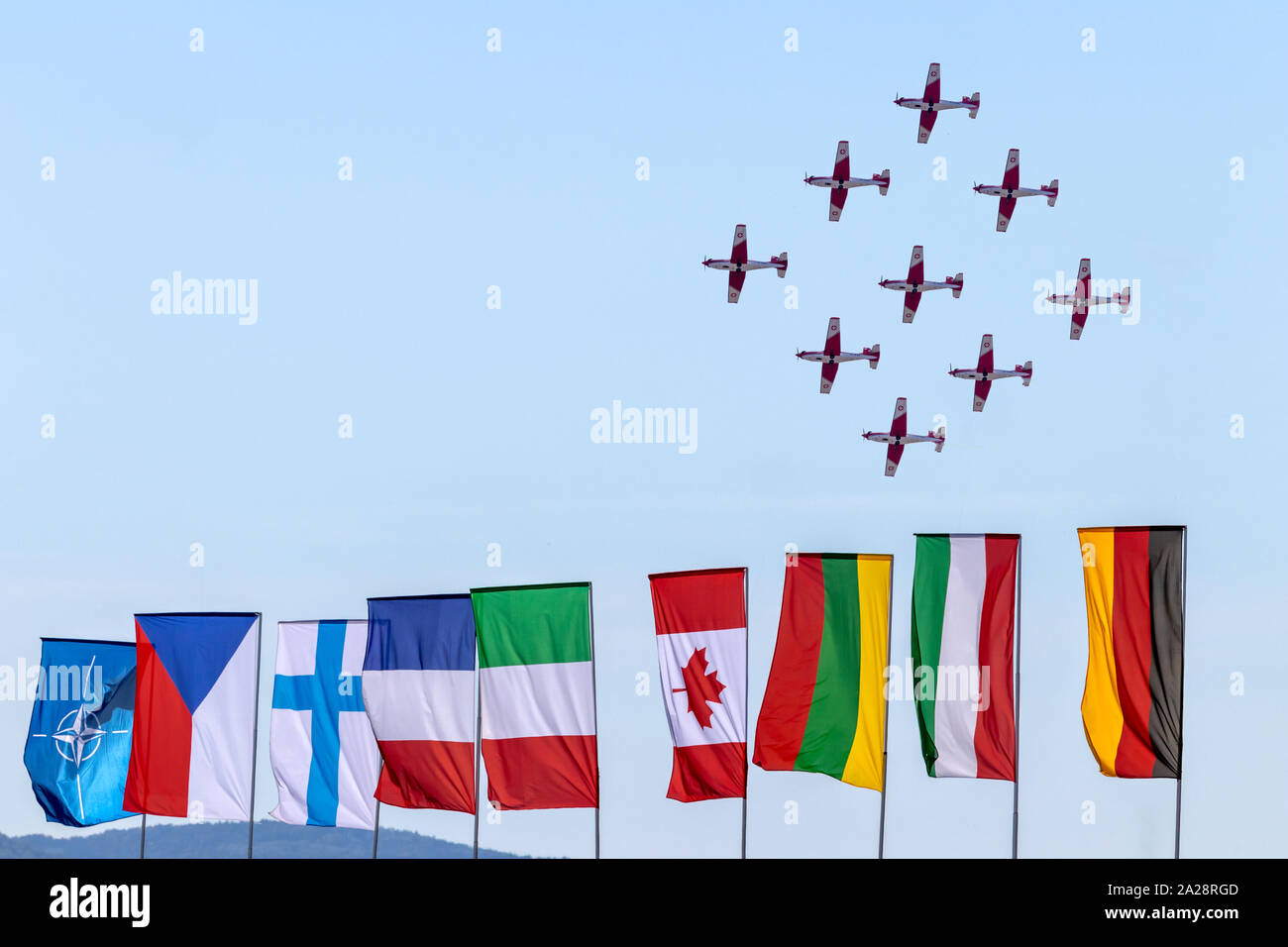OSTRAVA, RÉPUBLIQUE TCHÈQUE - le 22 septembre 2019 : Journées de l'OTAN. De l'Air suisse PC-7 TEAM effectue un vol de l'affichage. Drapeaux colorés des pays de l'OTAN. Banque D'Images