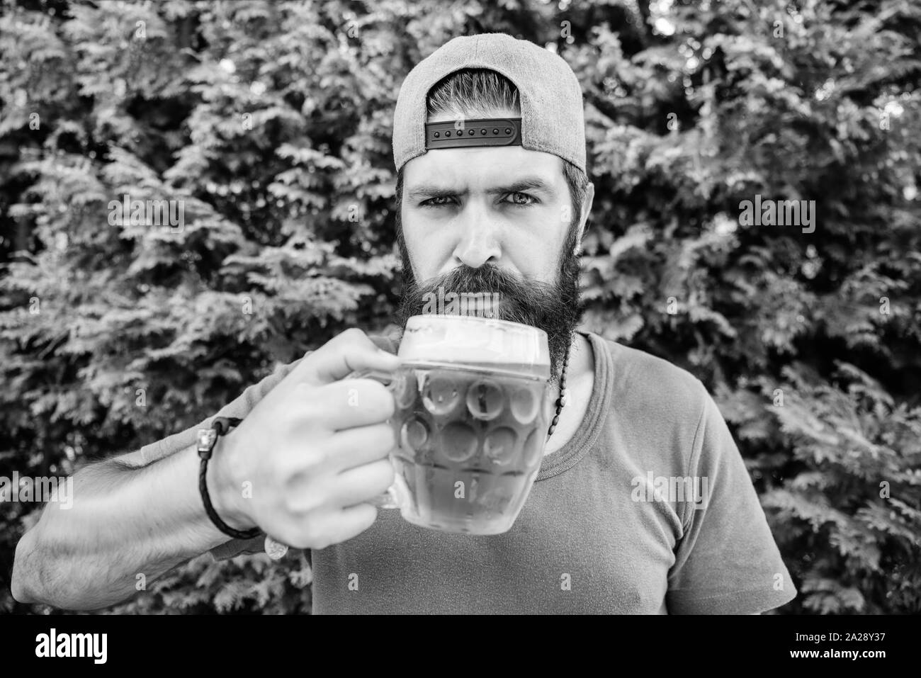 Son choix de boisson. Hipster buveur. Hipster holding beer mug. Hipster barbu de boire une bière sur la nature. Homme Hipster avec craft beer. L'homme brutal avec les habitudes de consommation. Boire seulement le meilleur de la bière. Banque D'Images