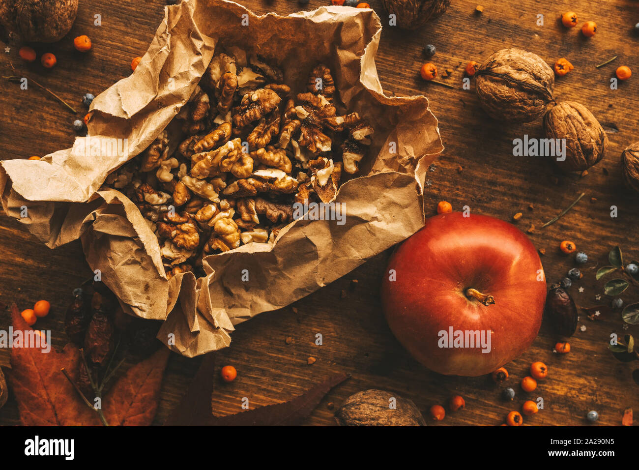 Rouge savoureux fruits pommes et noix sur la table décorée avec des détails de la saison d'automne Banque D'Images