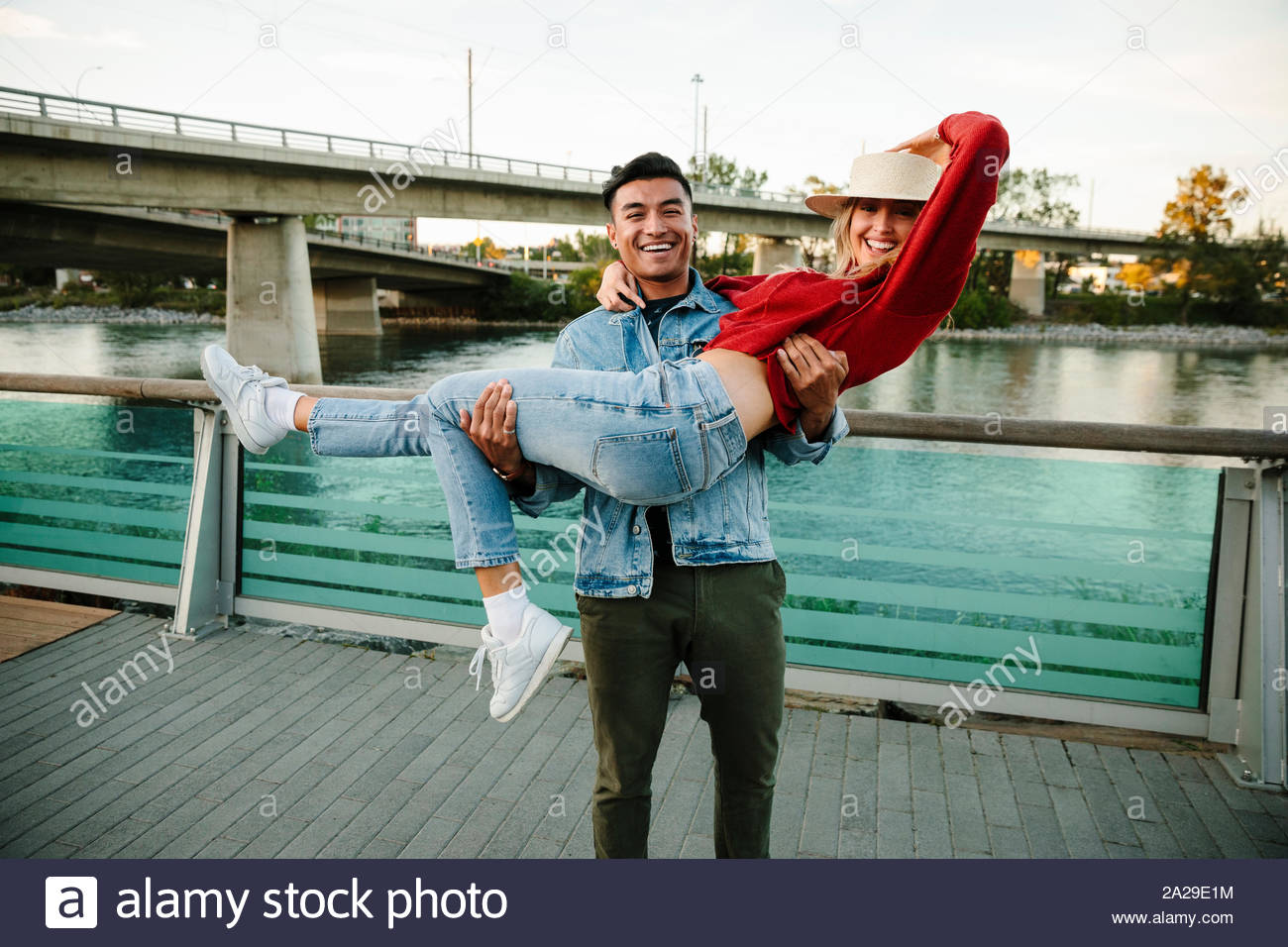 Portrait jeune couple ludique le long du front de mer urbain Banque D'Images
