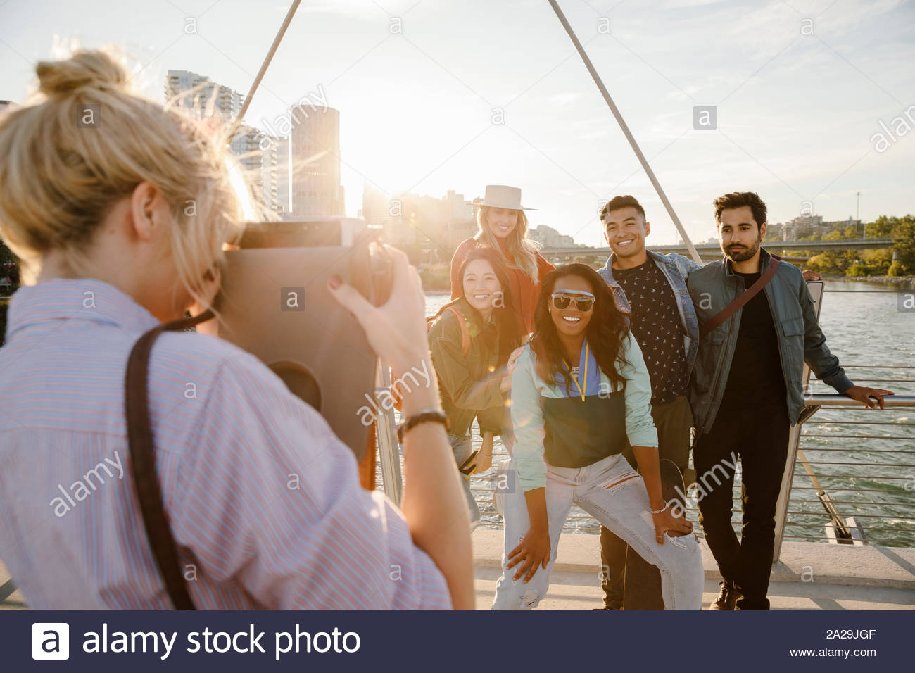 Jeune femme avec caméra numérique tablet photographier les beaux amis, pont urbain Banque D'Images