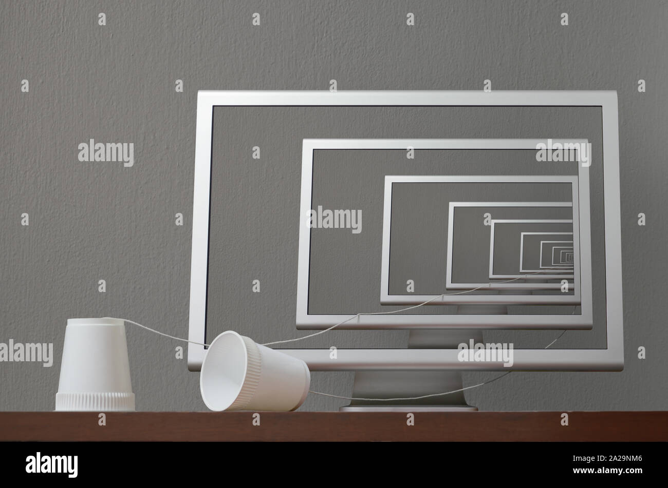 Effet de chambre d'écho, illustré par le téléphone de tasse dont l'une des extrémités passe par l'effet de réflexion infini dans l'écran d'ordinateur et revient au public. Banque D'Images