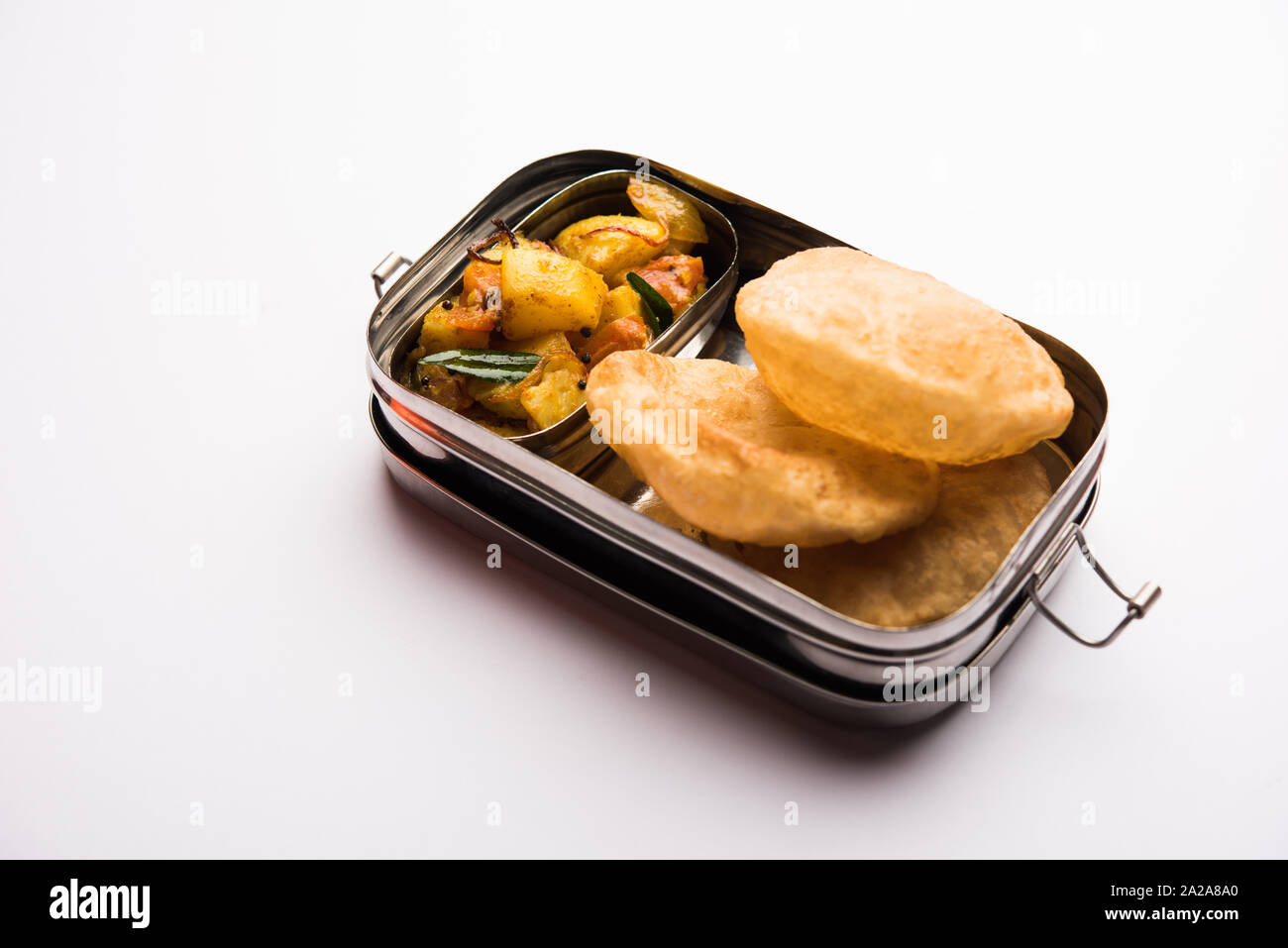 Boîte à lunch / Tiffin pour enfants Indiens, propose des hot poori/puri avec pomme de terre / aloo sabzi, selective focus Banque D'Images