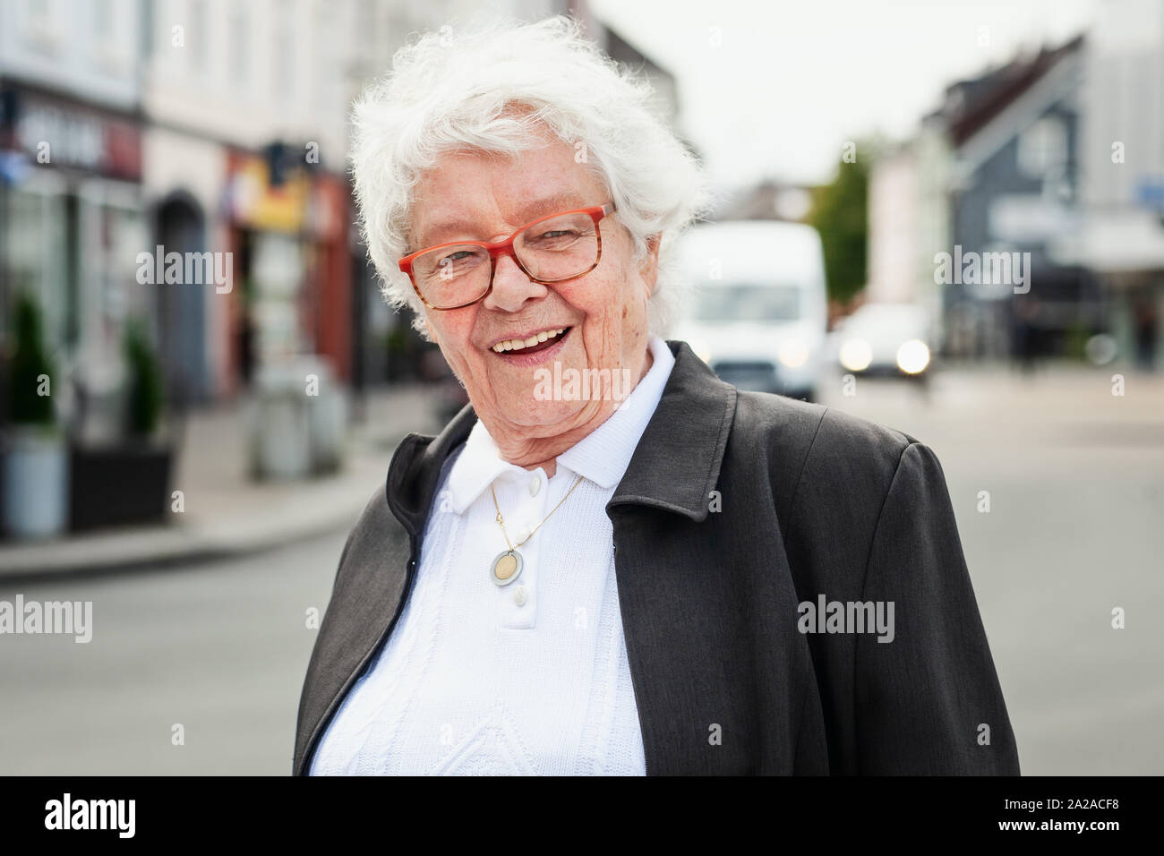 Cheerful smiling old woman walking in city Banque D'Images