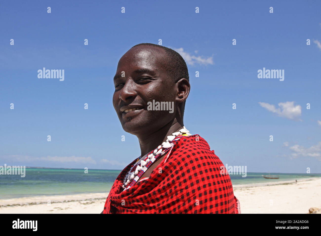 Homme massaï debout sur la plage, Zanzibar, l'île de Unguja, Tanzanie. Banque D'Images