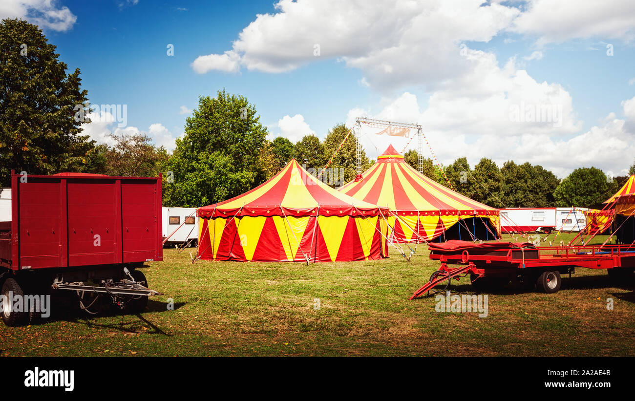 Tente de cirque dans la nature verte avec remorques de camping arbres et ciel bleu avec des nuages sur l'arrière-plan Banque D'Images