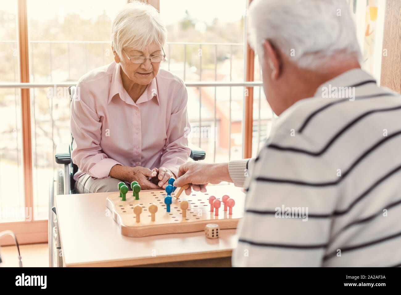 Deux personnes âgées dans une maison de soins infirmiers jouer à un jeu Banque D'Images