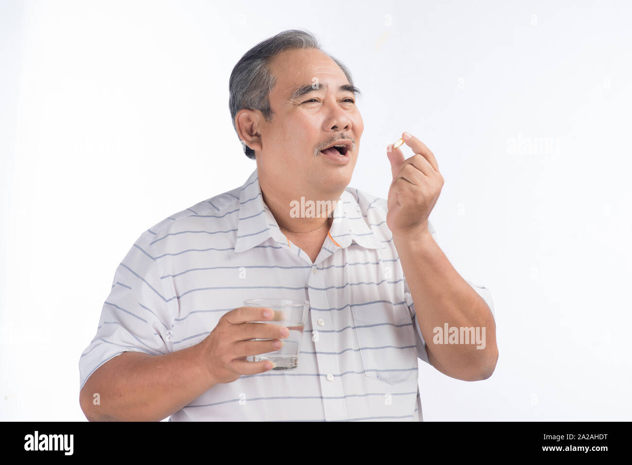 Asian senior man holding omega-3 capsule isolated on white Banque D'Images