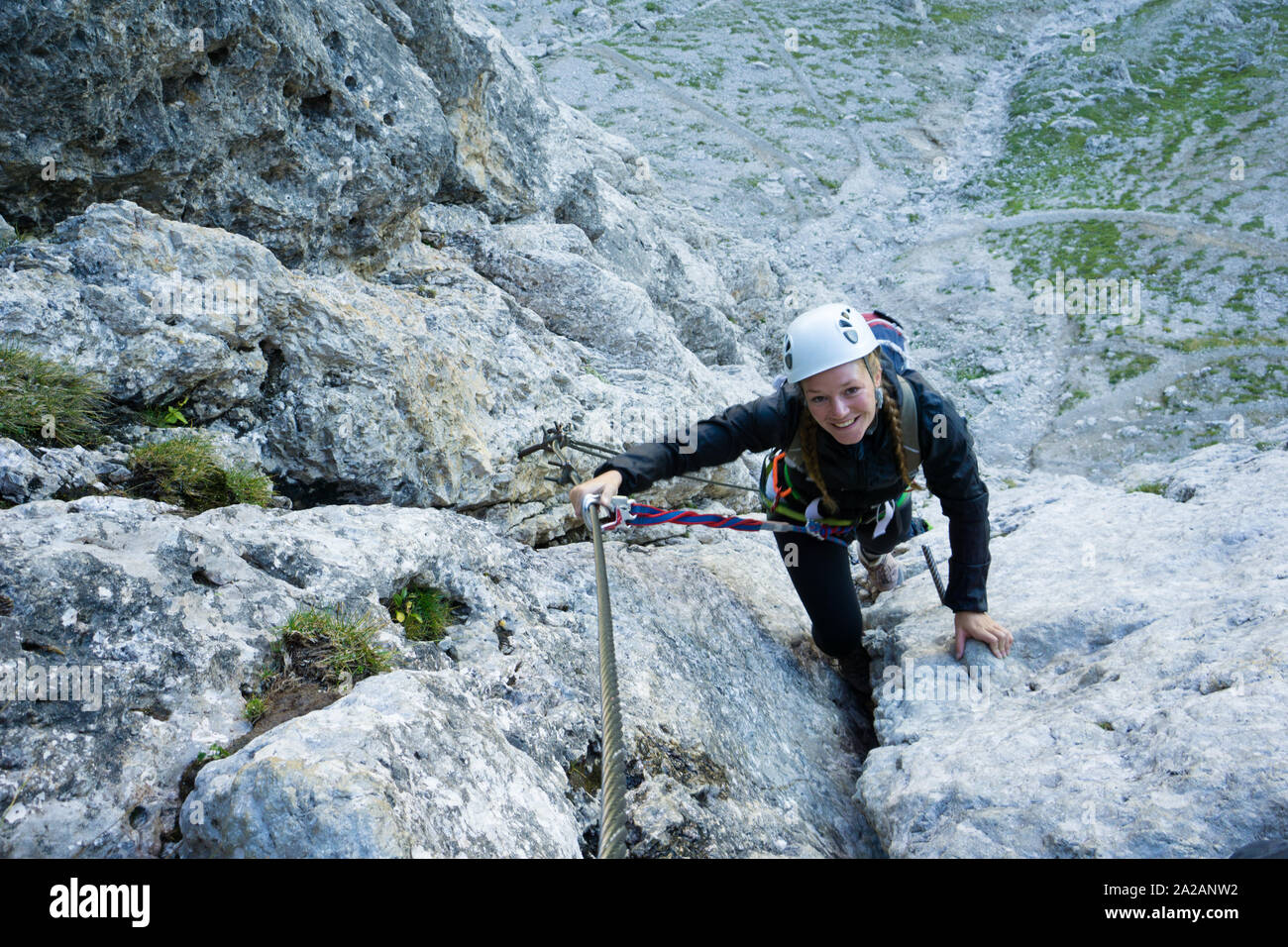 Belle femme d'alpinisme dans les Dolomites de l'Italie sur l'abrupte et difficile via ferrata Poessnecker Banque D'Images