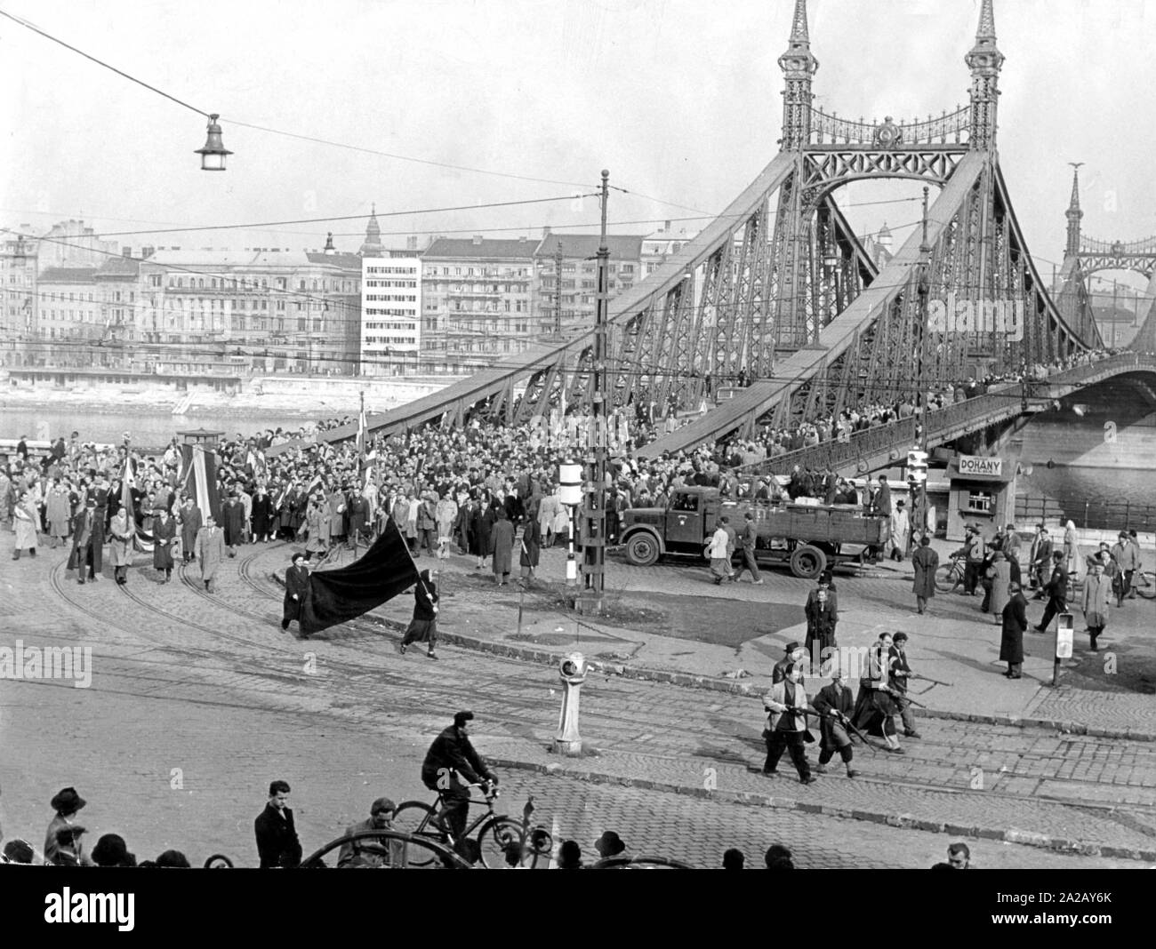 Les insurgés à pied à travers le pont de la liberté dans le centre-ville de Budapest. Avec le crâne noir pavillon honorer les morts de la Révolution. Le retrait de l'armée russe et le premier ministre Nagy a déclaré la Hongrie un état neutre. 11 jours plus tard, la rébellion a été brutalement réprimée. Banque D'Images