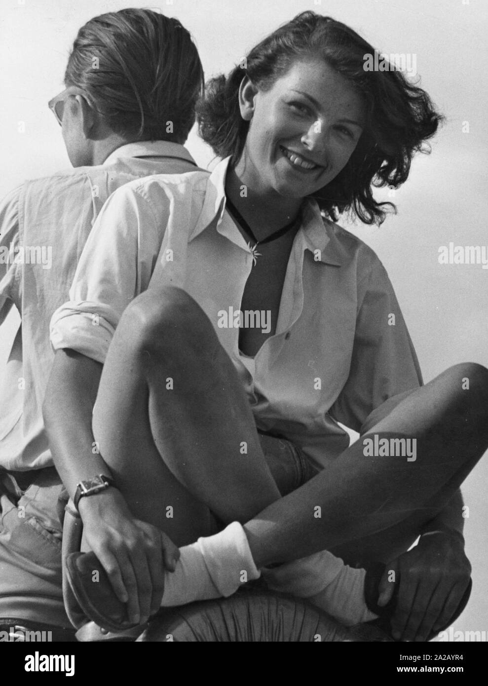 Une fille avec un pantalon court collier edelweiss et assis sur le dos d'un scooter. Banque D'Images