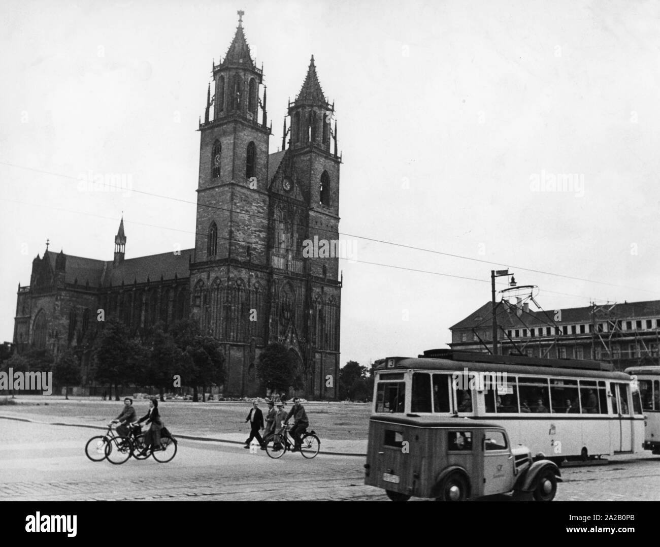 Vue sur la cathédrale de Magdebourg. Au premier plan, un tram et d'un van, les gens sont sur le chemin à pied et à vélo. Banque D'Images