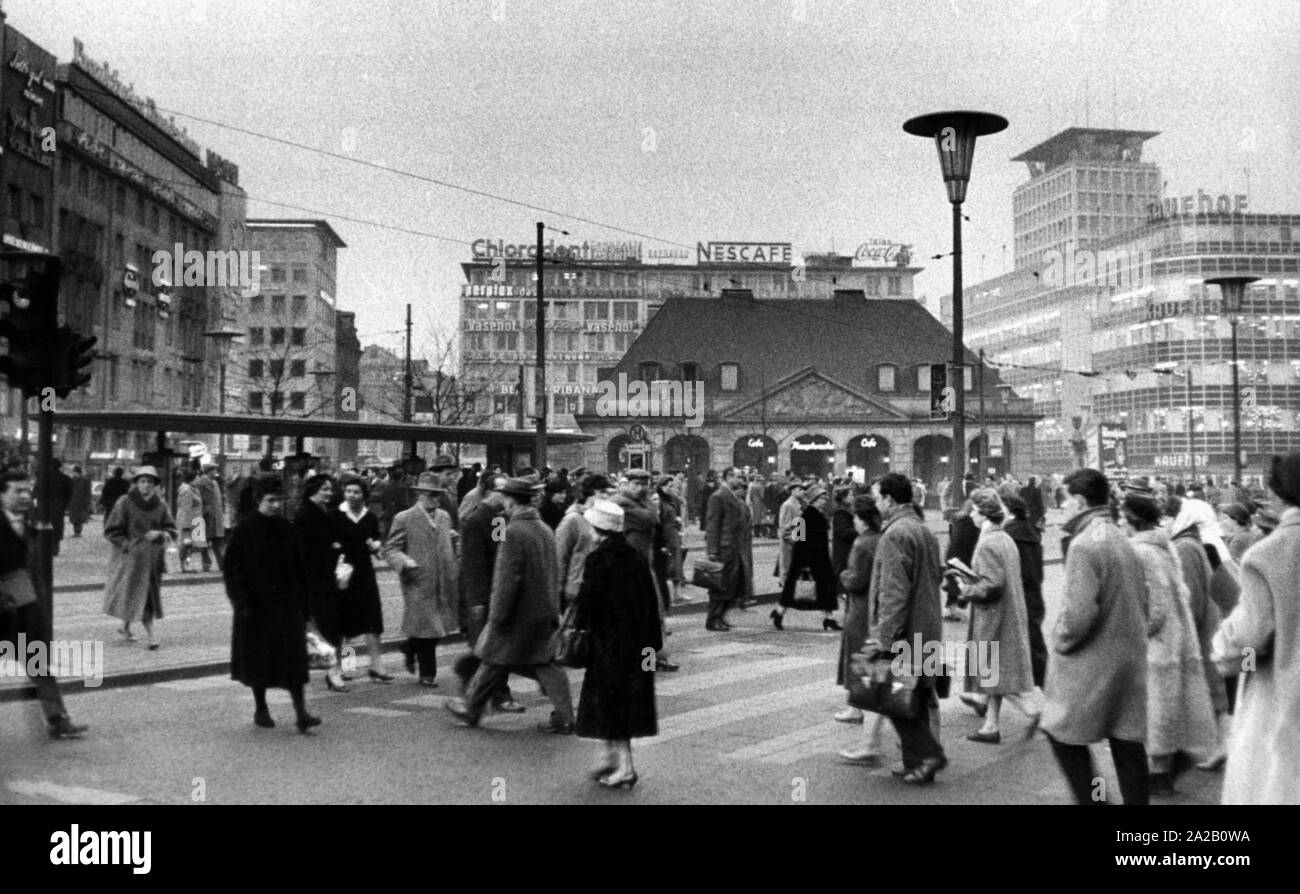 La photo montre de nombreux passants sur la place de la Hauptwache, un ancien bâtiment garde Baroque. Le Hauptwache était utilisé comme un café du début du 20ème siècle et reconstruite en 1954 après avoir été détruit pendant la Seconde Guerre mondiale. La photo date probablement de 1954-1959. Dans l'arrière-plan sont de nombreux grands magasins et édifices à bureaux. Sur leurs toits sont, entre autres, les affiches publicitaires de Nescafé, Chlorodent et Coca Cola. Sur la droite est un grand magasin Kaufhof. Banque D'Images