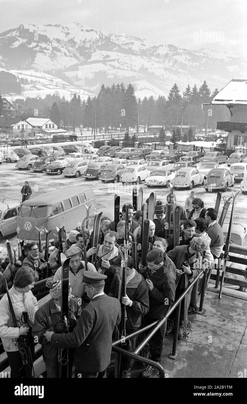 En attente de voir les skieurs qui veulent prendre le téléphérique jusqu'à l'Hahnenkamm. La photo a été prise à l'occasion de la course du Hahnenkamm se déroulant en même temps, et a eu lieu sur l'une des pistes. La course du Hahnenkamm a eu lieu depuis 1931 sur le Hahnenkamm de Kitzbühel. Dans l'arrière-plan, le terrain de stationnement avec l'voitures en stationnement des visiteurs. Banque D'Images
