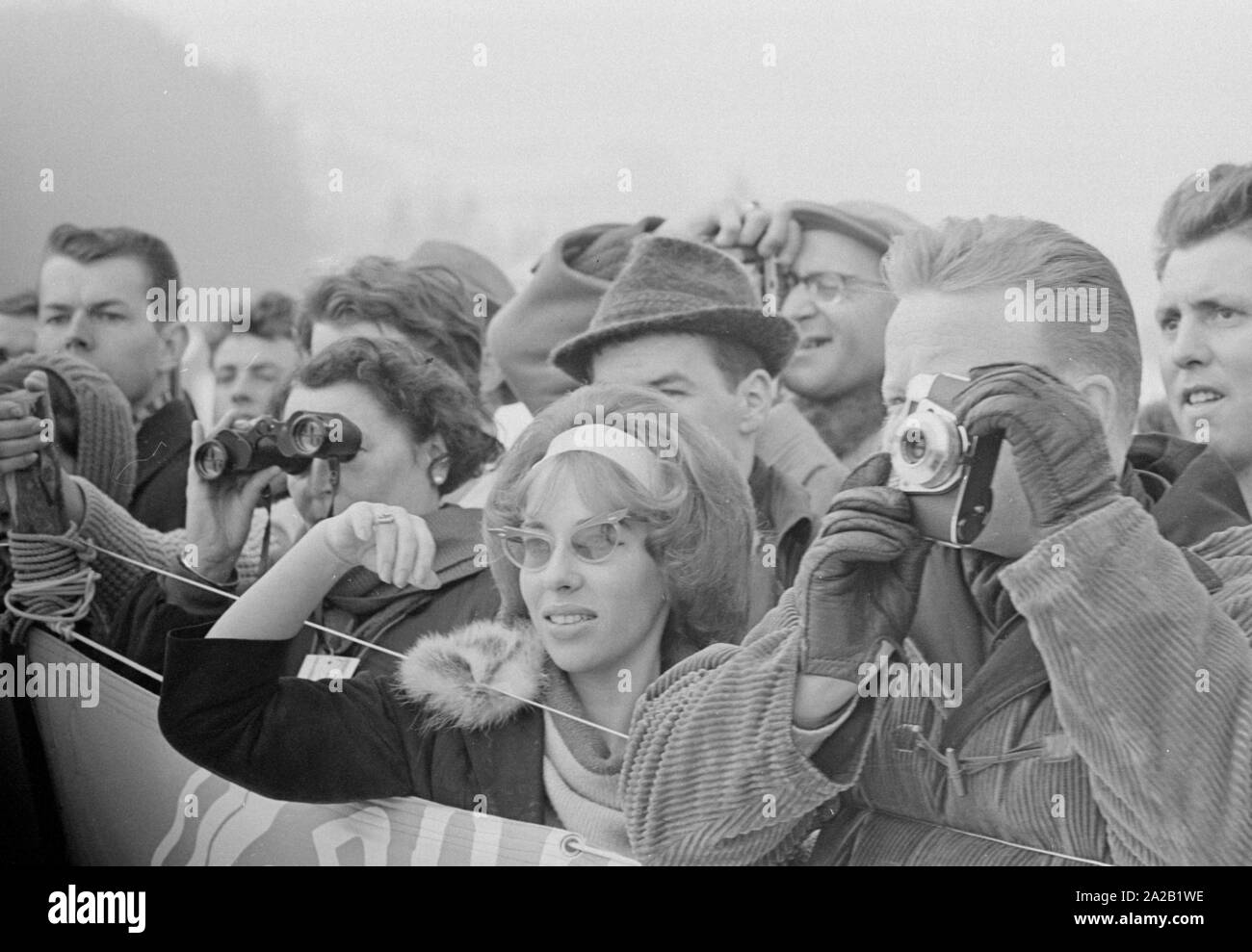 Vue de la foule de spectateurs à la piste. Certains prennent des photos avec leurs appareils photo, une femme regarde à travers des jumelles. La course du Hahnenkamm a eu lieu sur le Hahnenkamm de Kitzbühel depuis 1931. Banque D'Images