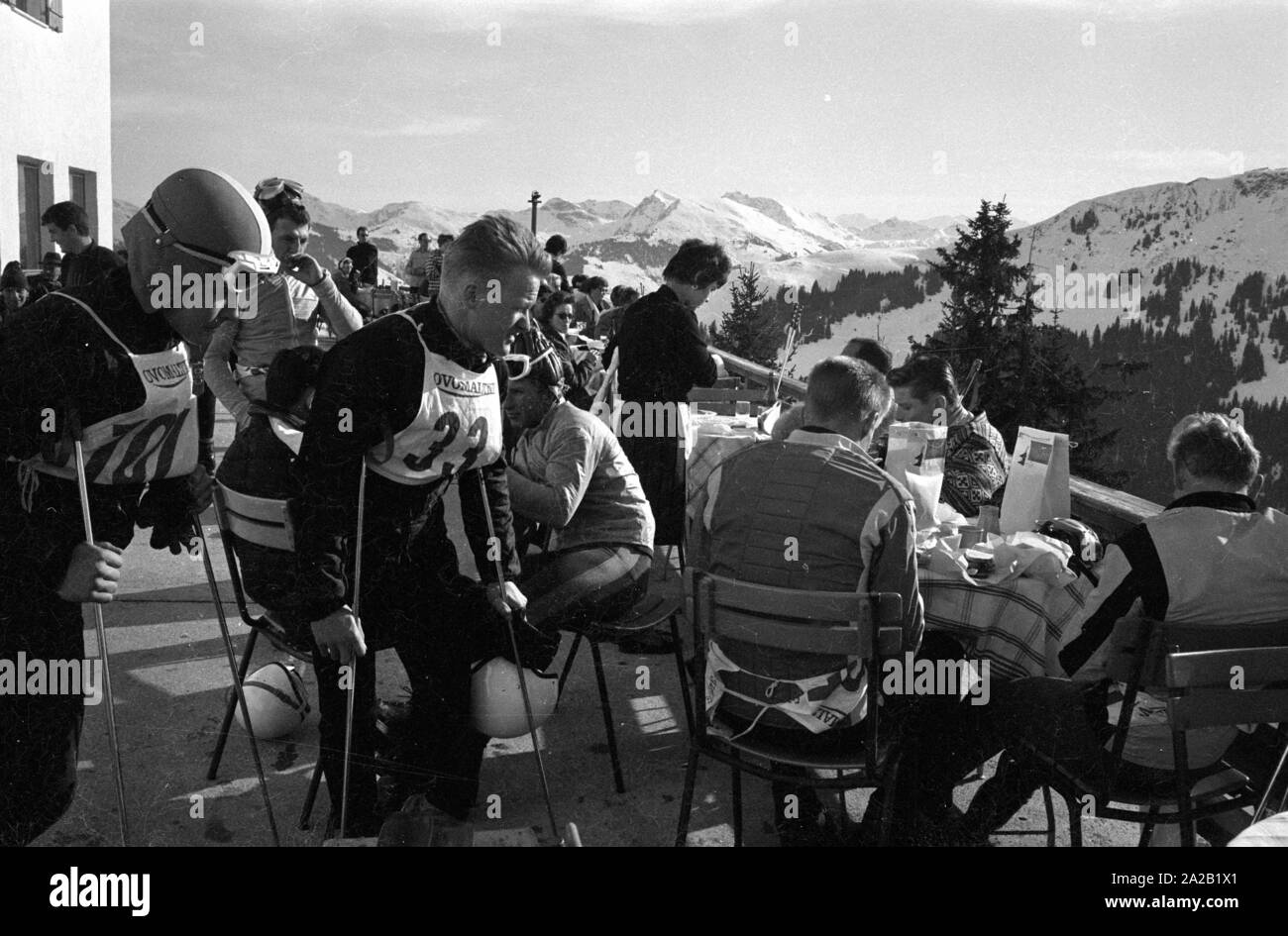 Certains coureurs prennent une pause sur la terrasse d'un chalet de ski. En dehors d'eux, les visiteurs et touristes de ski s'asseoir là et, pour certaines pentes ont été ouvertes au public. La course du Hahnenkamm a eu lieu sur le Hahnenkamm de Kitzbühel depuis 1931. Banque D'Images