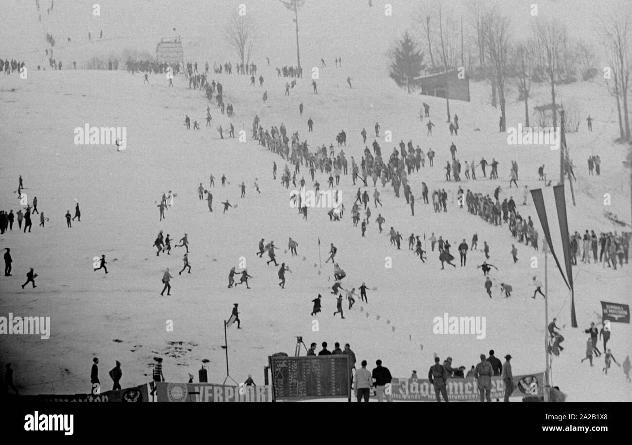 À l'occasion de la course du Hahnenkamm en janvier 1962, de nombreux spectateurs s'étaient rassemblés près de la piste et de la ligne d'arrivée. C'est une photo aérienne des spectateurs et les enfants jouant sur le cours, qui a probablement été prise avant la course a commencé. La course du Hahnenkamm a eu lieu sur le Hahnenkamm de Kitzbühel depuis 1931. Banque D'Images