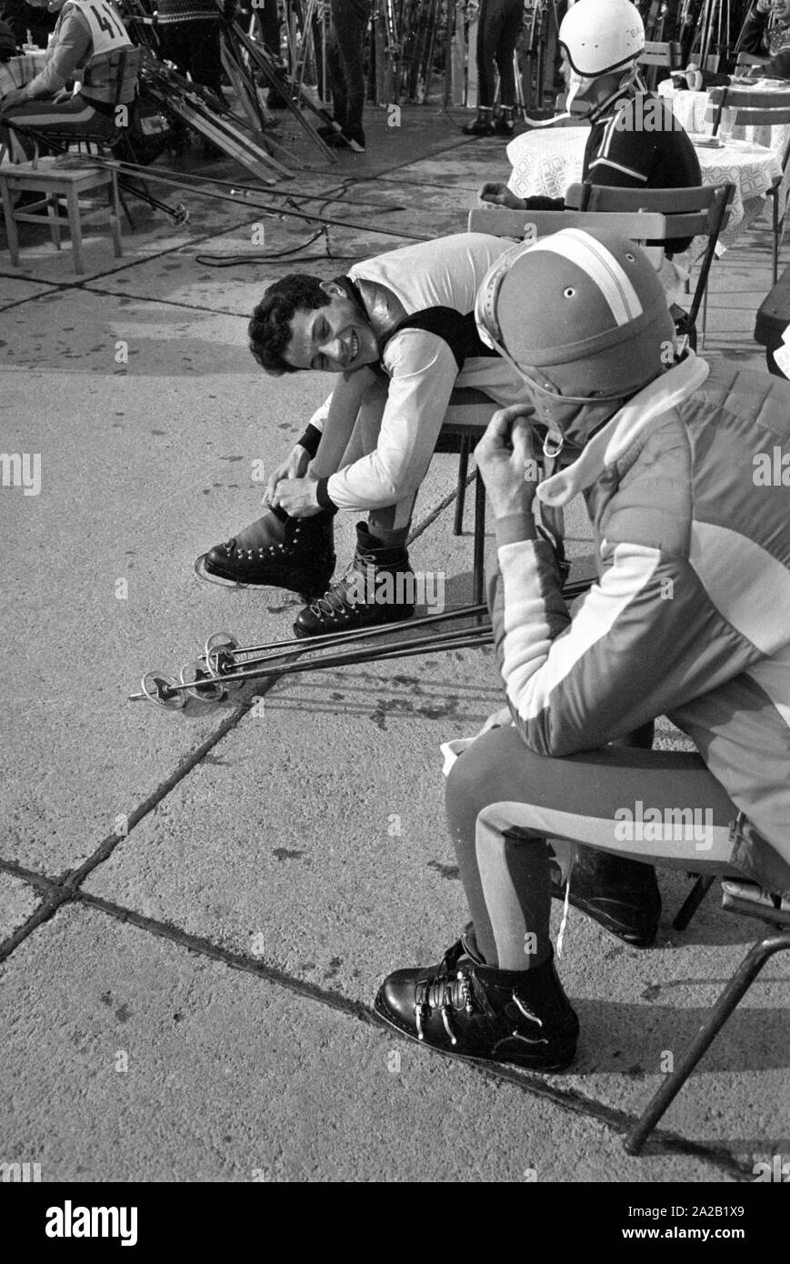 Certains coureurs prennent une pause sur la terrasse d'un chalet de ski pendant la course du Hahnenkamm. La course du Hahnenkamm a eu lieu sur le Hahnenkamm de Kitzbühel depuis 1931. Banque D'Images