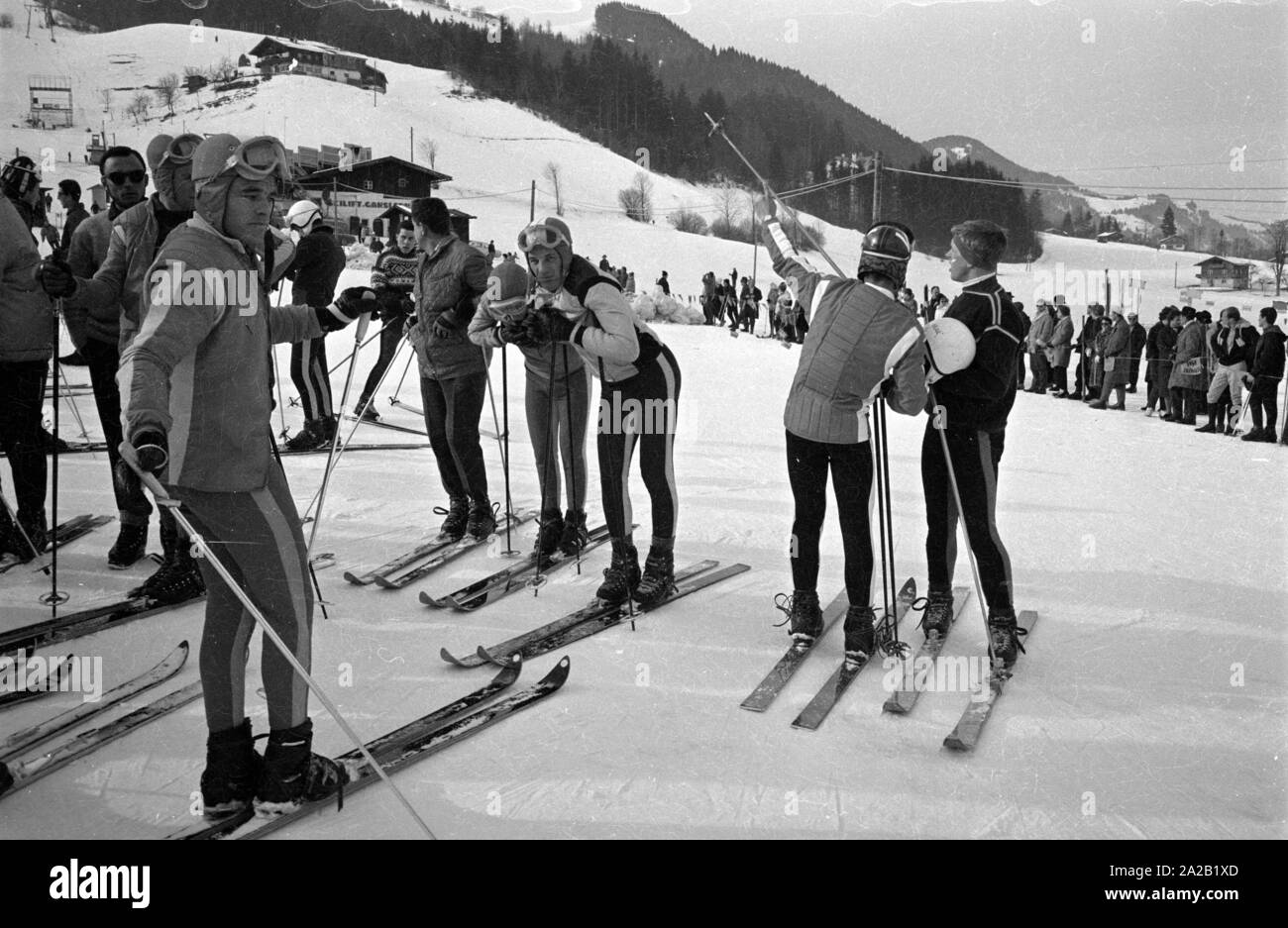 Vue des participants d'une compétition de ski dans la finale après leur course. Dans l'arrière-plan, les spectateurs sont debout dans la zone de but. La course du Hahnenkamm a eu lieu sur le Hahnenkamm de Kitzbühel depuis 1931. Banque D'Images