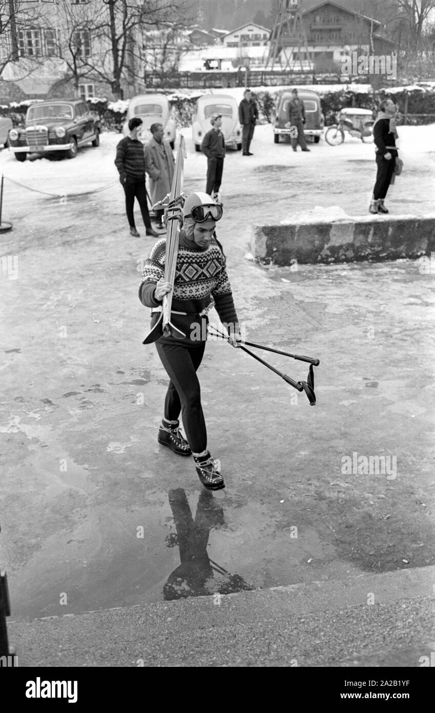 Photo de skieur de Toni Sailer avec ses skis sur ses épaules sur son chemin vers le téléphérique de l'Hahnenkamm. Il a pris part à la course de ski qui a eu lieu il y en janvier 1962. La course du Hahnenkamm a eu lieu sur le Hahnenkamm de Kitzbühel depuis 1931. Banque D'Images
