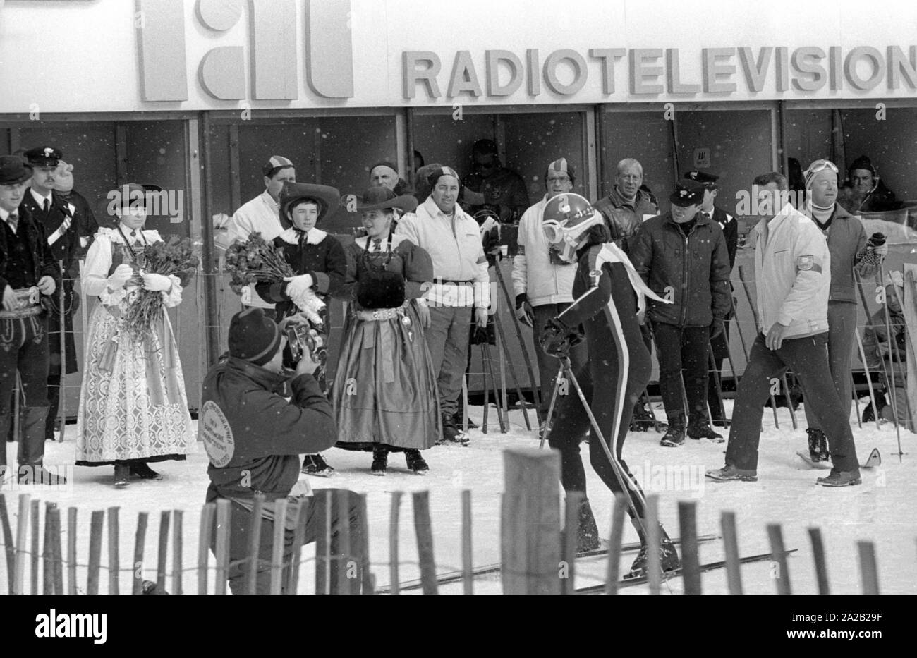Championnats du Monde de Ski alpin a eu lieu à Val Gardena entre 7.2.1970 et 15.2.1970, et il avait été la seule Coupe du monde jusqu'à présent, les résultats ont été inclus dans la Coupe du Monde de Ski Alpin.à l'arrière-plan, un vestiaire. Il a été possible de rendre compte en direct de ici. Au premier plan, les membres d'un groupe de costumes, ainsi que des officiers de police, les athlètes et les journalistes. Banque D'Images