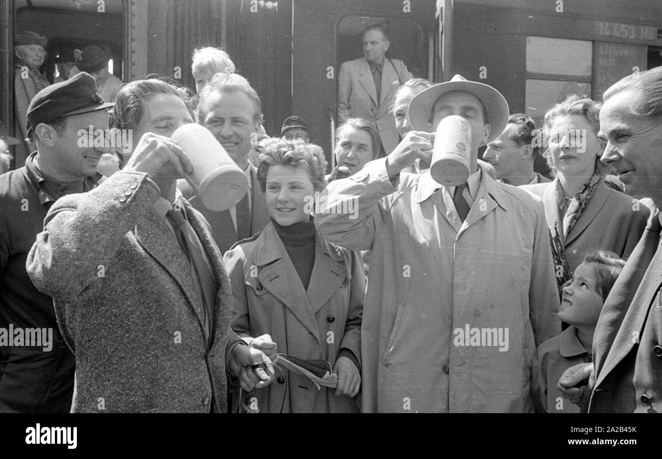 La photo montre probablement membres de l'expédition dans l'Himalaya à la large pic entre août et décembre 1954. Le voyage pour la région himalayenne explique le jour de départ le 28 avril. Les alpinistes participantes disent au revoir à leurs proches et les parties intéressées à la gare principale de Munich. Les participants ont vite boire une dernière bière bavaroise. Banque D'Images