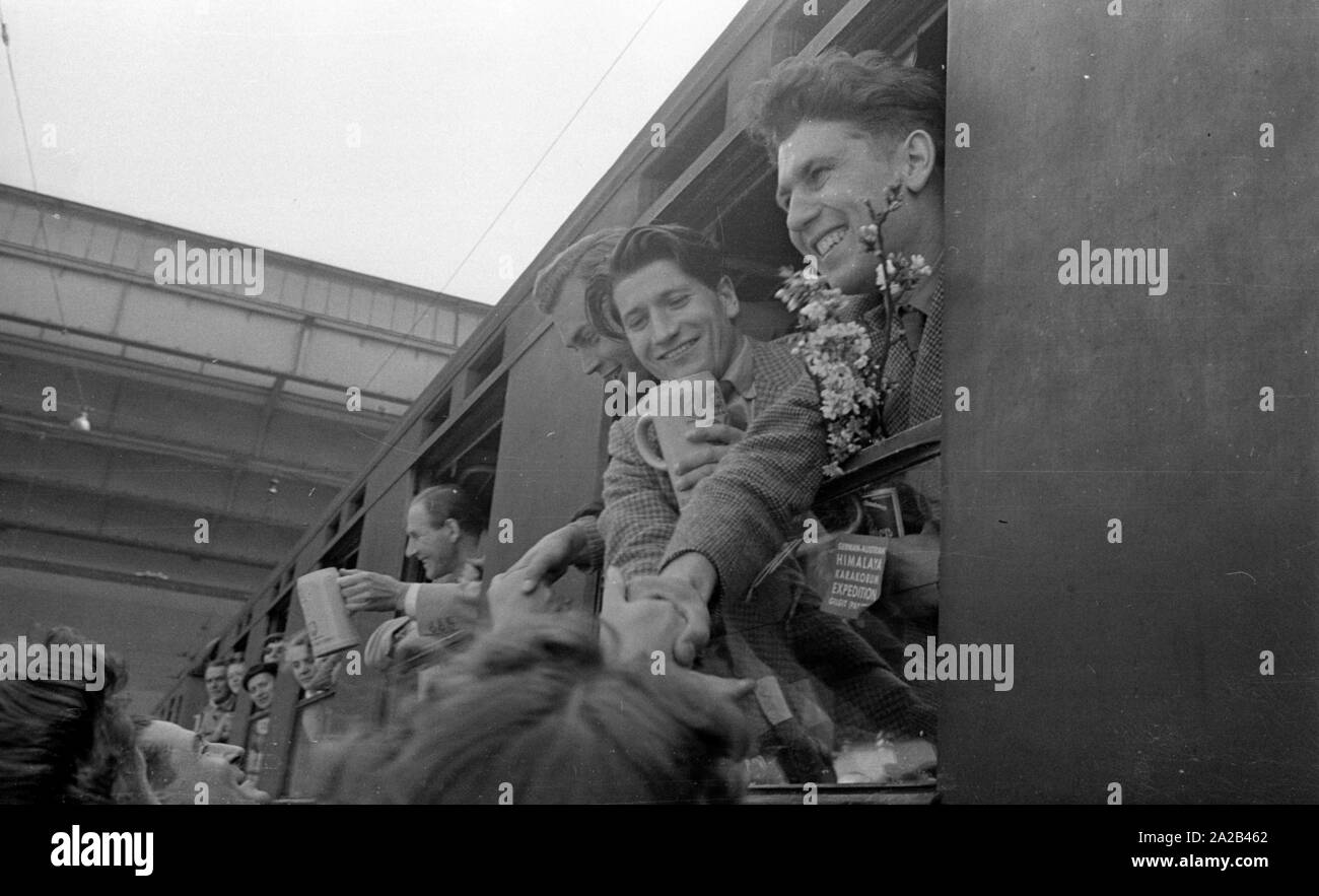 La photo montre probablement membres de l'expédition dans l'Himalaya à la large pic entre août et décembre 1954. Le voyage pour la région himalayenne explique le jour de départ le 28 avril. Les alpinistes participantes disent au revoir à leurs proches et les parties intéressées à la gare principale de Munich. Ils vague à la population sur la plate-forme des fenêtres des wagons. Banque D'Images