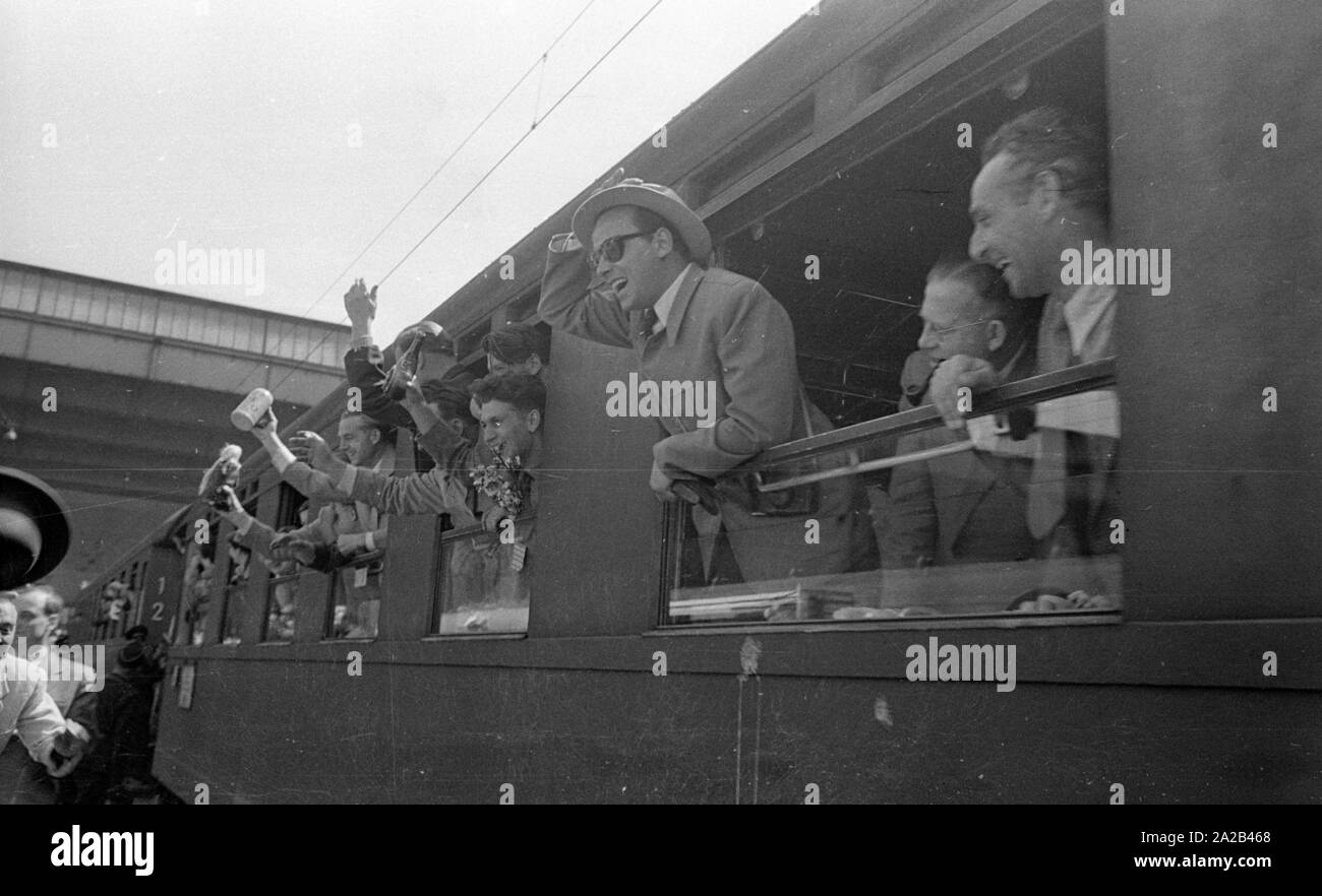 La photo montre probablement membres de l'expédition dans l'Himalaya à la large pic entre août et décembre 1954. Le voyage pour la région himalayenne explique le jour de départ le 28 avril. Les alpinistes participantes disent au revoir à leurs proches et les parties intéressées à la gare principale de Munich. Ils vague à la population sur la plate-forme des fenêtres des wagons. Banque D'Images