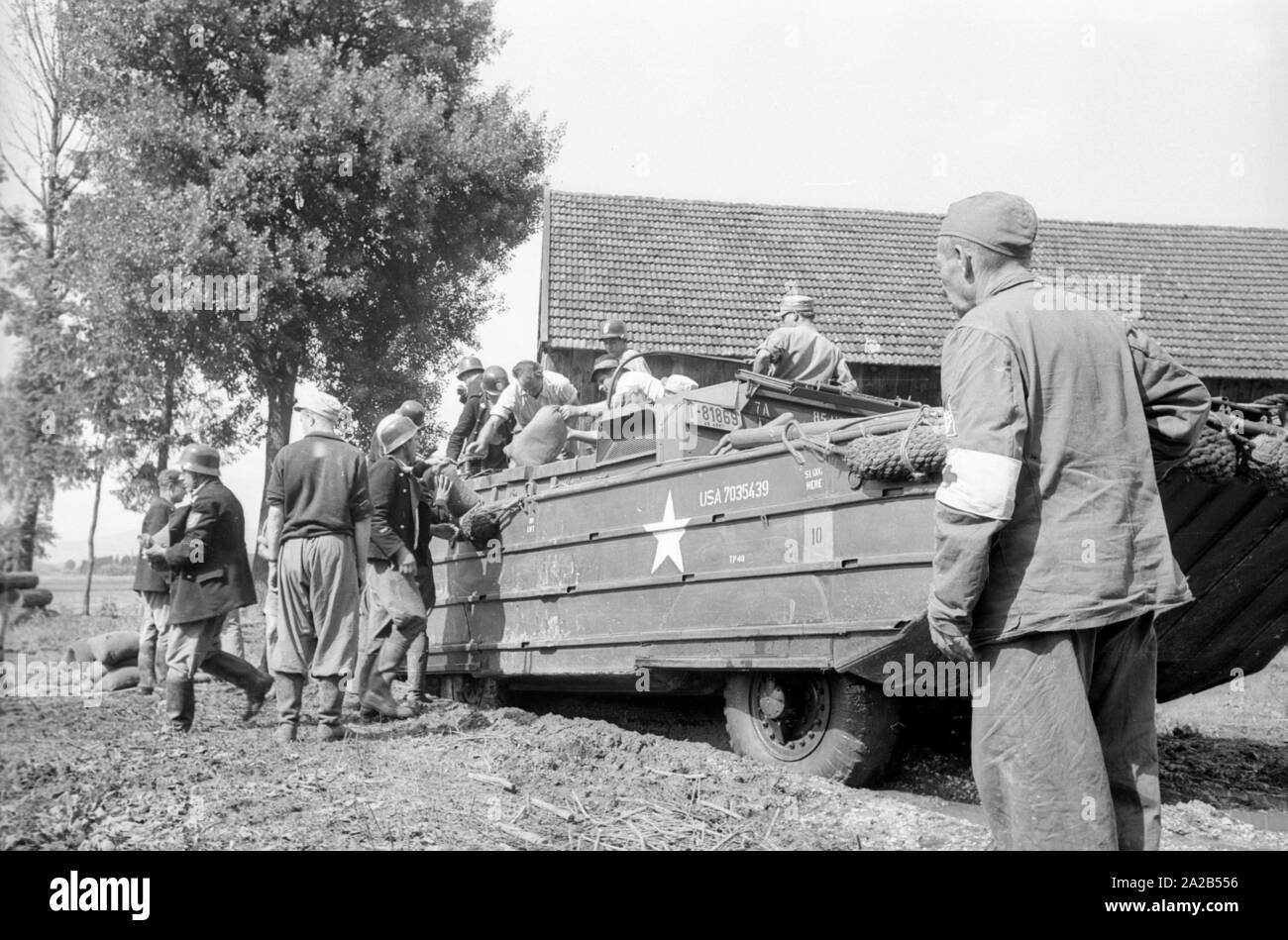 L'inondation à Passau et d'autres parties de la Basse Bavière (juillet, 1954) ont également appelé l'inondation du siècle. Le Danube, l'Inn et l'Ilz avaient débordé leurs banques, et ont inondé les villes et villages. Photo d'un véhicule amphibie de l'armée américaine. À bord, les membres de la THW, le service d'incendie et de la police anti-émeute de Bavière. Au premier plan, un membre de la Croix-Rouge. Banque D'Images