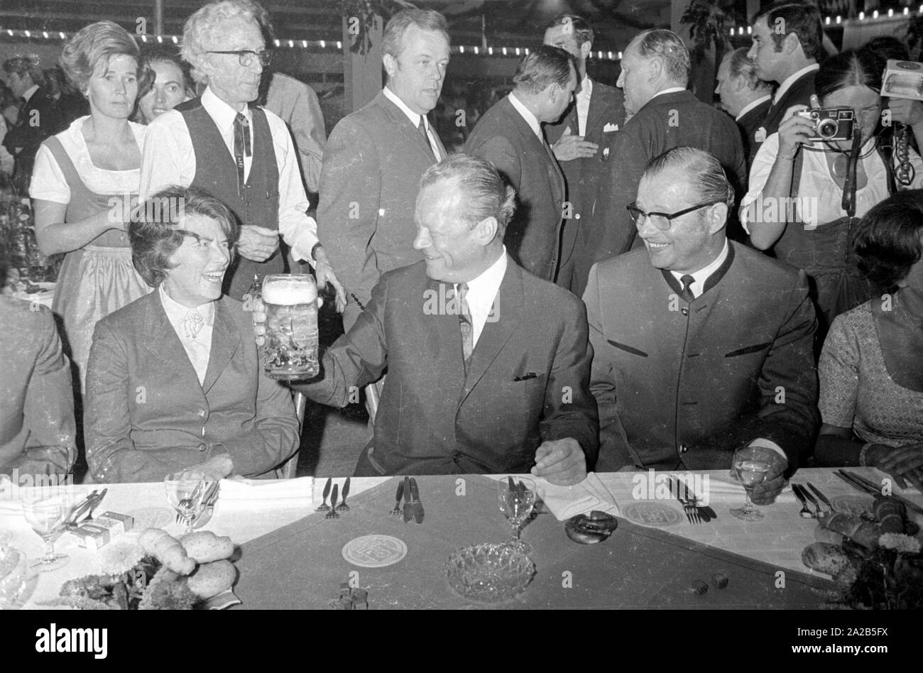 À l'occasion de l'Oktoberfest en 1970 Willy Brandt était un invité dans le chapiteau de l'Fischer-Vroni. La photo le montre avec une tasse de bière, d'autres invités sont assis autour de lui. Banque D'Images