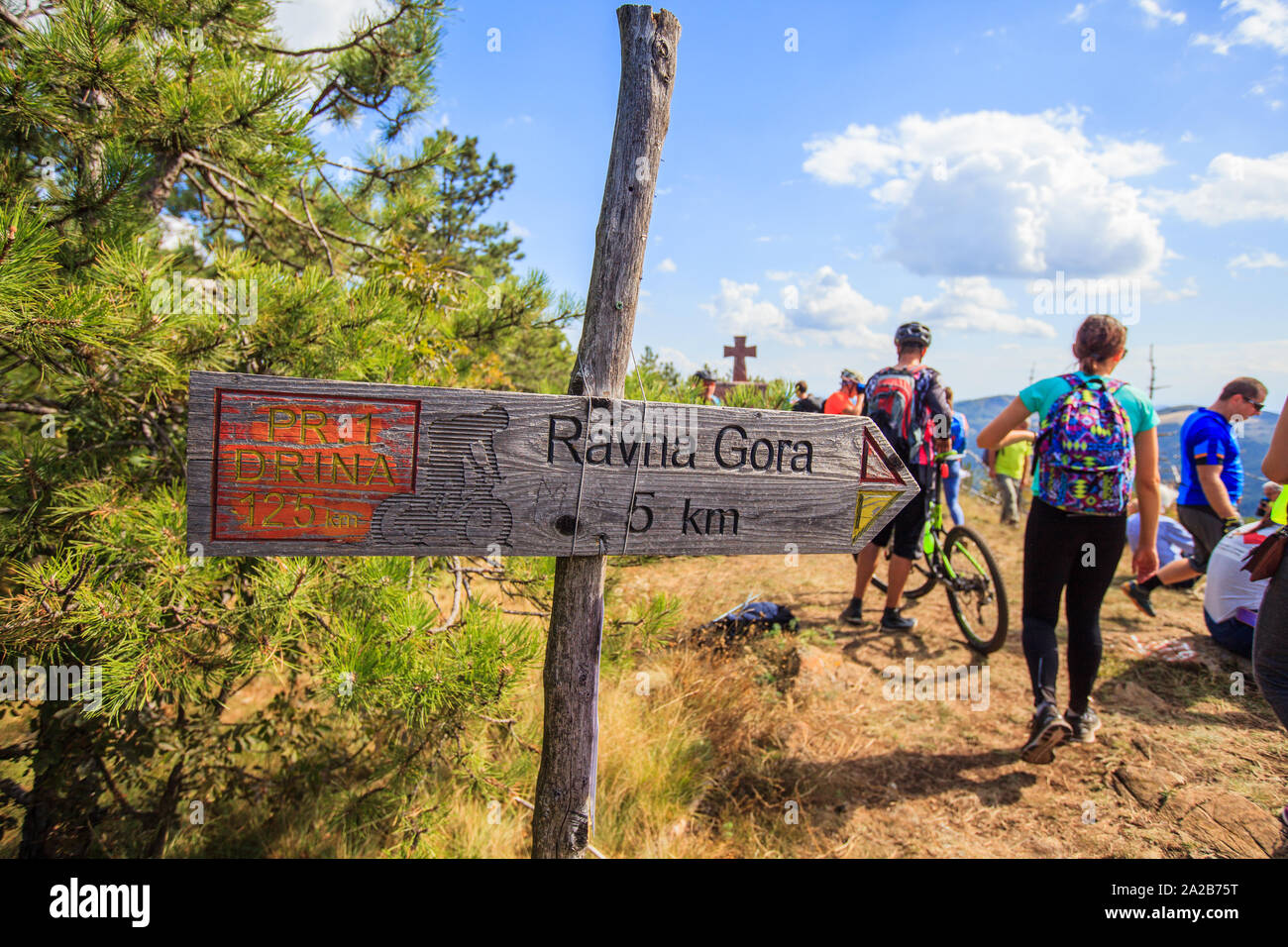 Piste en bois des pointeurs sur sentier de randonnée. Les panneaux en montagne Rajac , Serbie. Groupe de gens actifs prêts pour l'aventure en arrière-plan. Banque D'Images