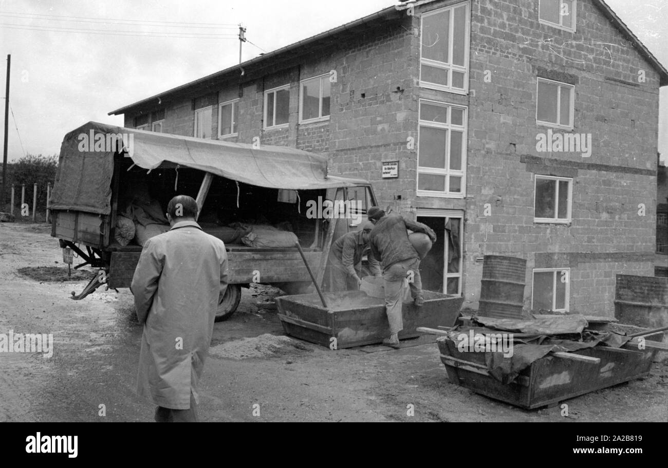 Deux travailleurs de la construction ciment mélange sur le site de construction d'un bâtiment résidentiel neuf en 038884. Banque D'Images