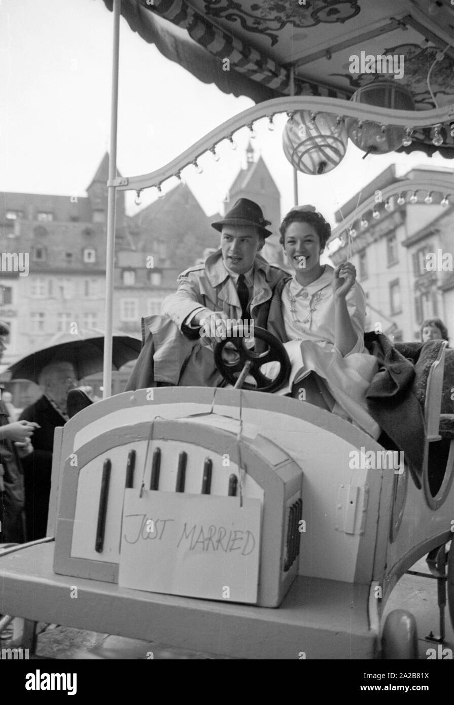 A senior couple montè sur un carrousel à Bâle. Ils ont accroché un signe sur la voiture avec l'inscription 'Just Married'. L'un des conjoints est américaine. Banque D'Images