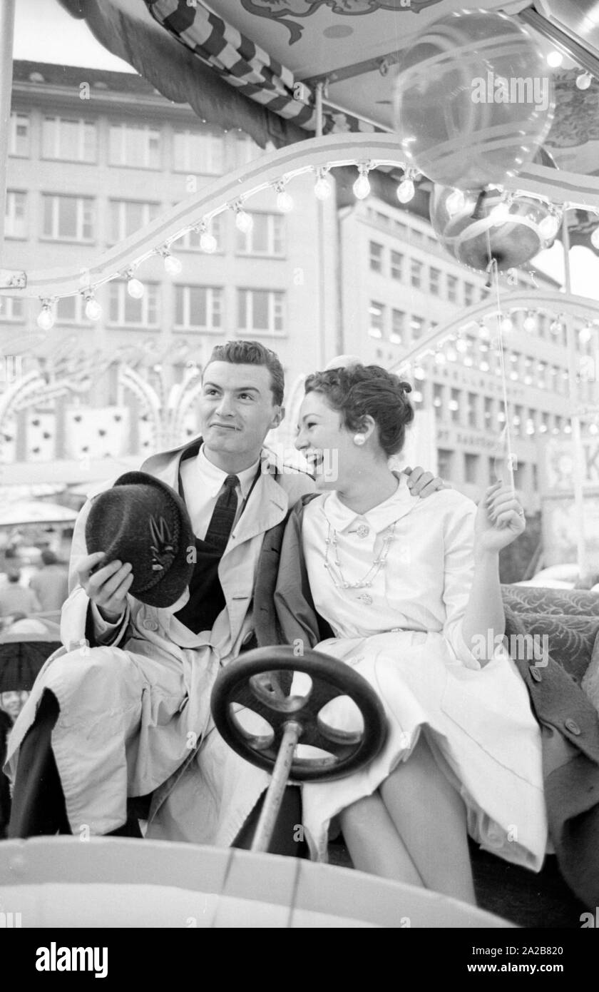 Un couple nouvellement marié à Bâle lors d'un carrousel ride. L'un des conjoints est américaine. Banque D'Images
