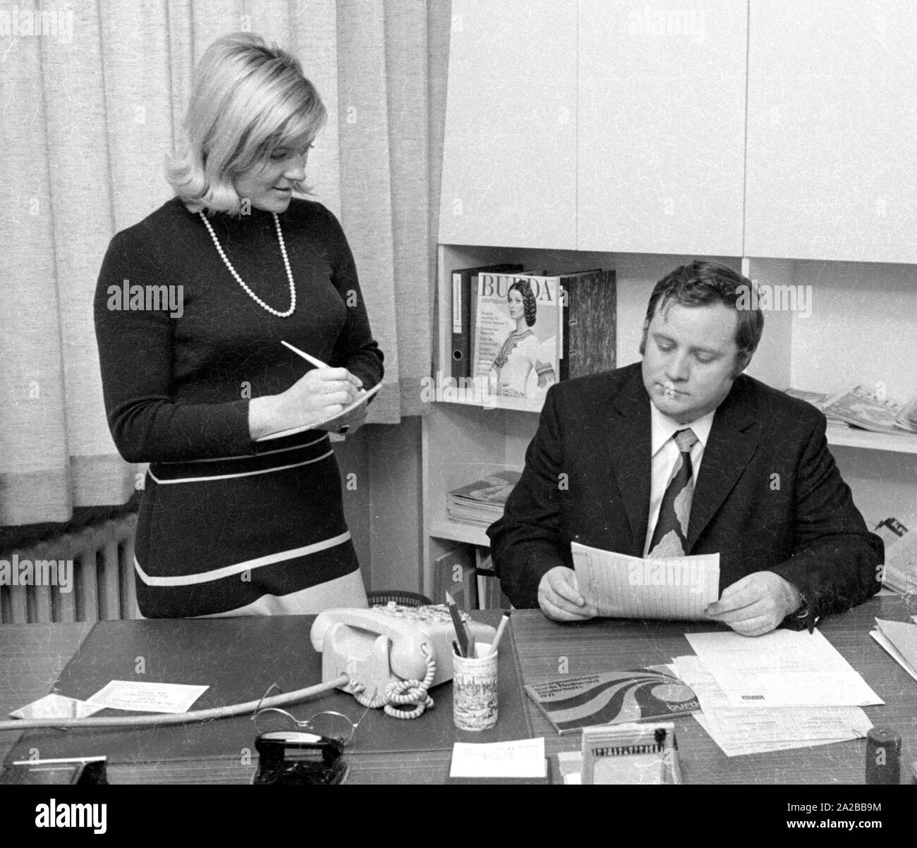 Un secrétaire prend des notes au cours d'une réunion avec son superviseur. Banque D'Images