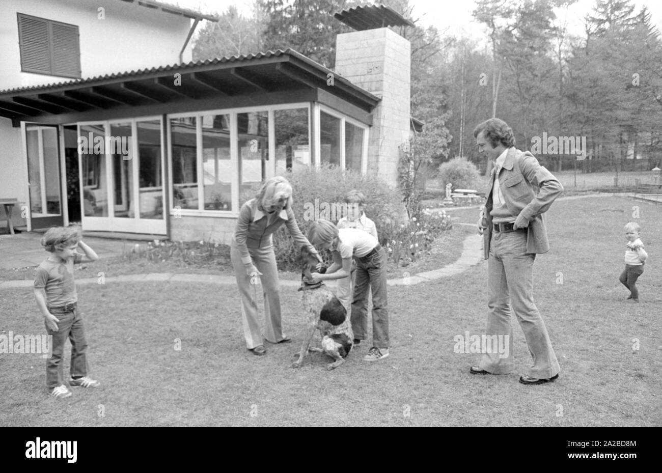 Accueil Histoire avec la famille Beckenbauer. Sur la photo : Le Beckenbauer famille joue dans le jardin avec le chien, de gauche à droite : Stephan, Brigitte Beckebauer, Thomas, Michael (derrière) et Franz Beckenbauer. Banque D'Images