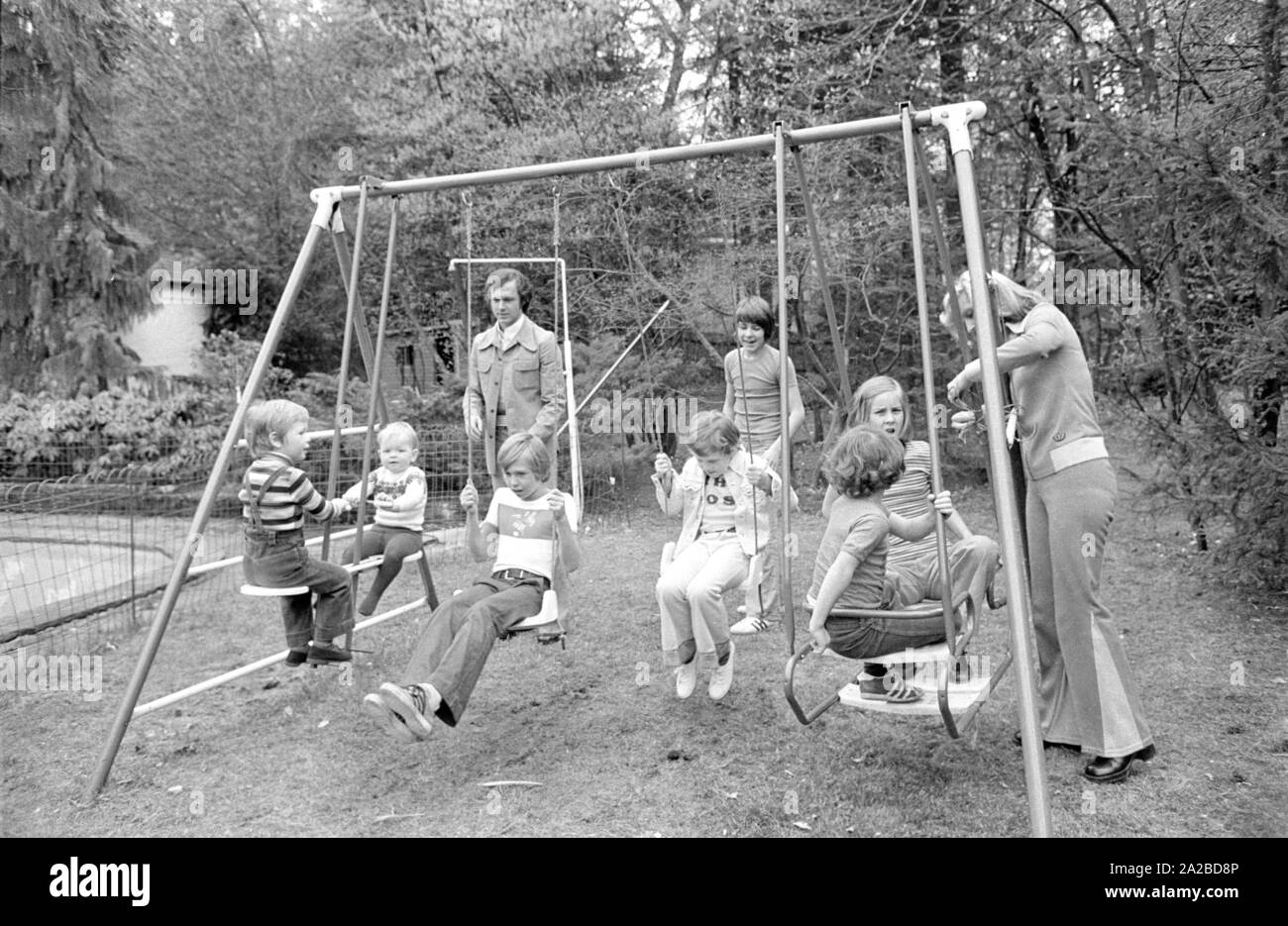 Accueil Histoire avec la famille Beckenbauer. Sur la photo : Franz Beckenbauer et Brigitte à la balançoire dans le jardin. Banque D'Images