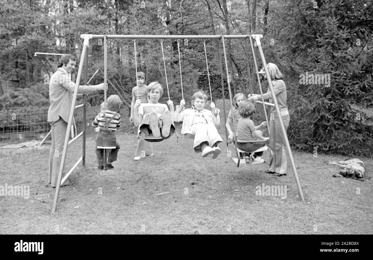 Accueil Histoire avec la famille Beckenbauer. Sur la photo : le couple Beckenbauer et les enfants sur la balançoire dans le jardin. Banque D'Images