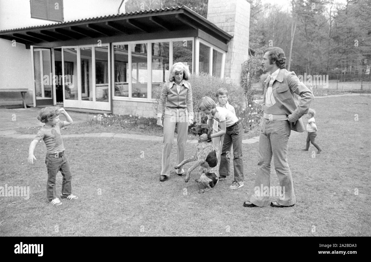 Accueil Histoire avec la famille Beckenbauer. Sur la photo : Le Beckenbauer famille joue dans le jardin avec le chien, de gauche à droite : Stephan, Brigitte Beckebauer, Thomas, Michael (derrière) et Franz Beckenbauer. Banque D'Images
