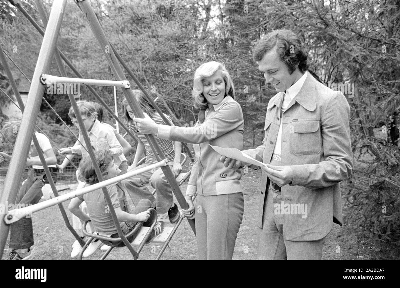 Accueil Histoire avec la famille Beckenbauer. Sur la photo : Franz Beckenbauer et Brigitte à la balançoire dans le jardin. Banque D'Images