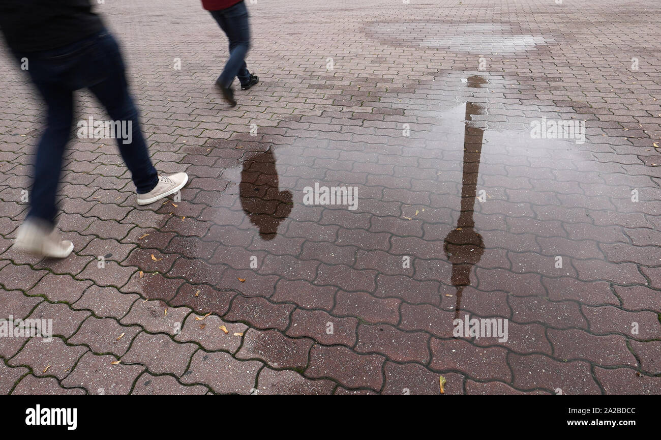 Berlin, Allemagne. 09Th Oct, 2019. La tour de télévision et les piétons se reflètent dans une flaque d'eau de pluie. Credit : Jörg Carstensen/dpa/Alamy Live News Banque D'Images