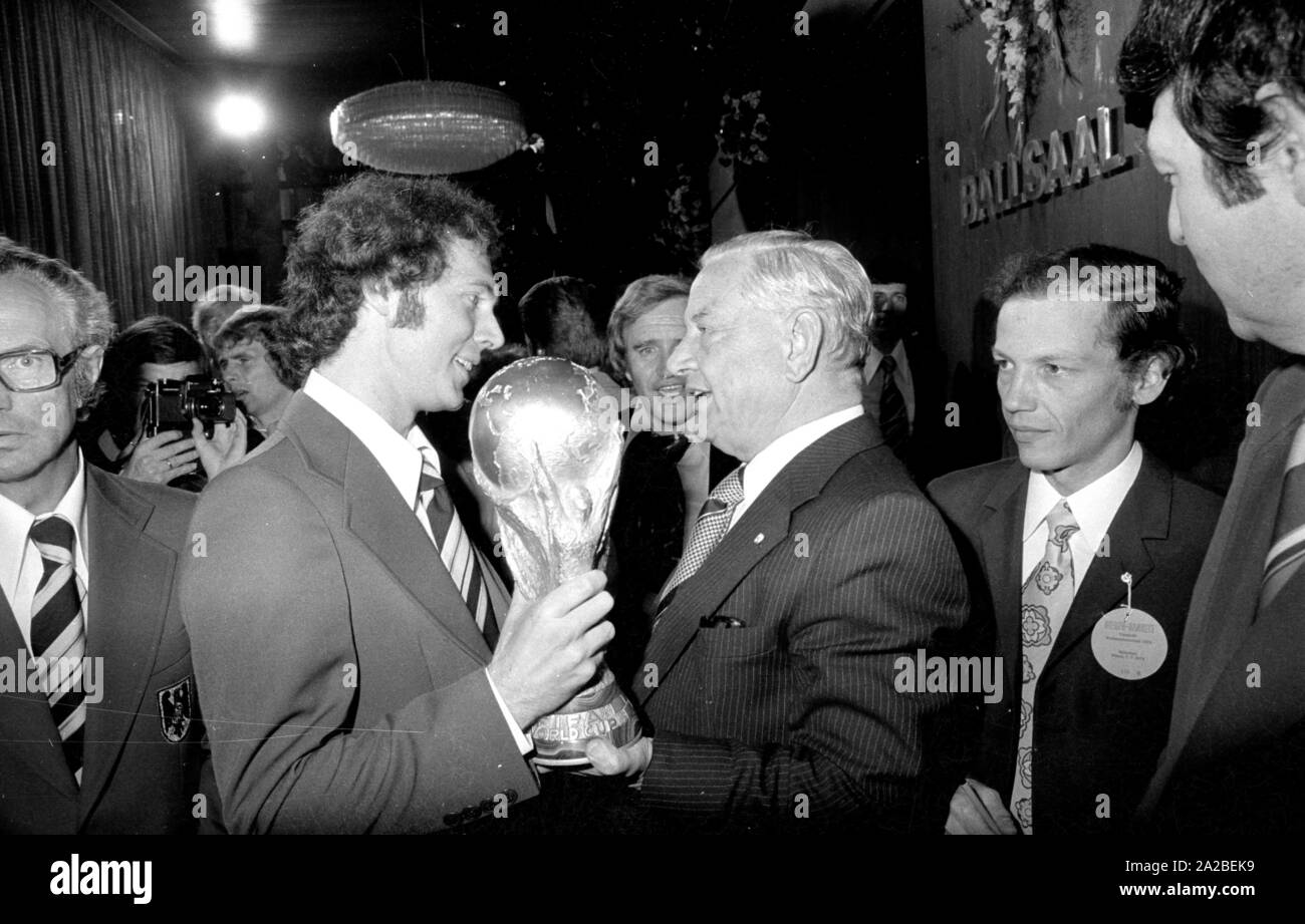 Joueur de Franz Beckenbauer (l.) et le Premier Ministre bavarois Alfons Goppel (r.) lors du banquet du président fédéral dans l'hôtel Hilton à Munich. Ils détiennent la FIFA World Cup Trophy dans leurs mains. Banque D'Images