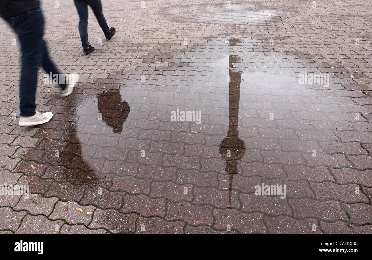 Berlin, Allemagne. 09Th Oct, 2019. La tour de télévision et les piétons se reflètent dans une flaque d'eau de pluie. Credit : Jörg Carstensen/dpa/Alamy Live News Banque D'Images
