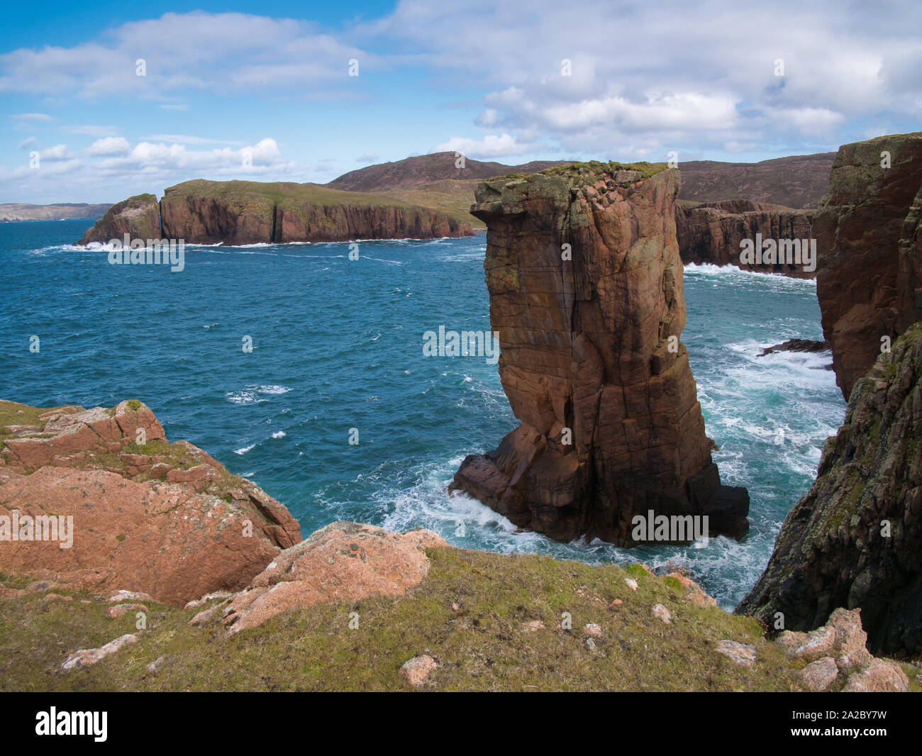 La pile de la mer et les falaises près de North Ham sur Muckle Roe, Shetland, UK - la roche est de l'Intrusion de Muckle Roe - granit, roche ignée - granophyrique pour Banque D'Images