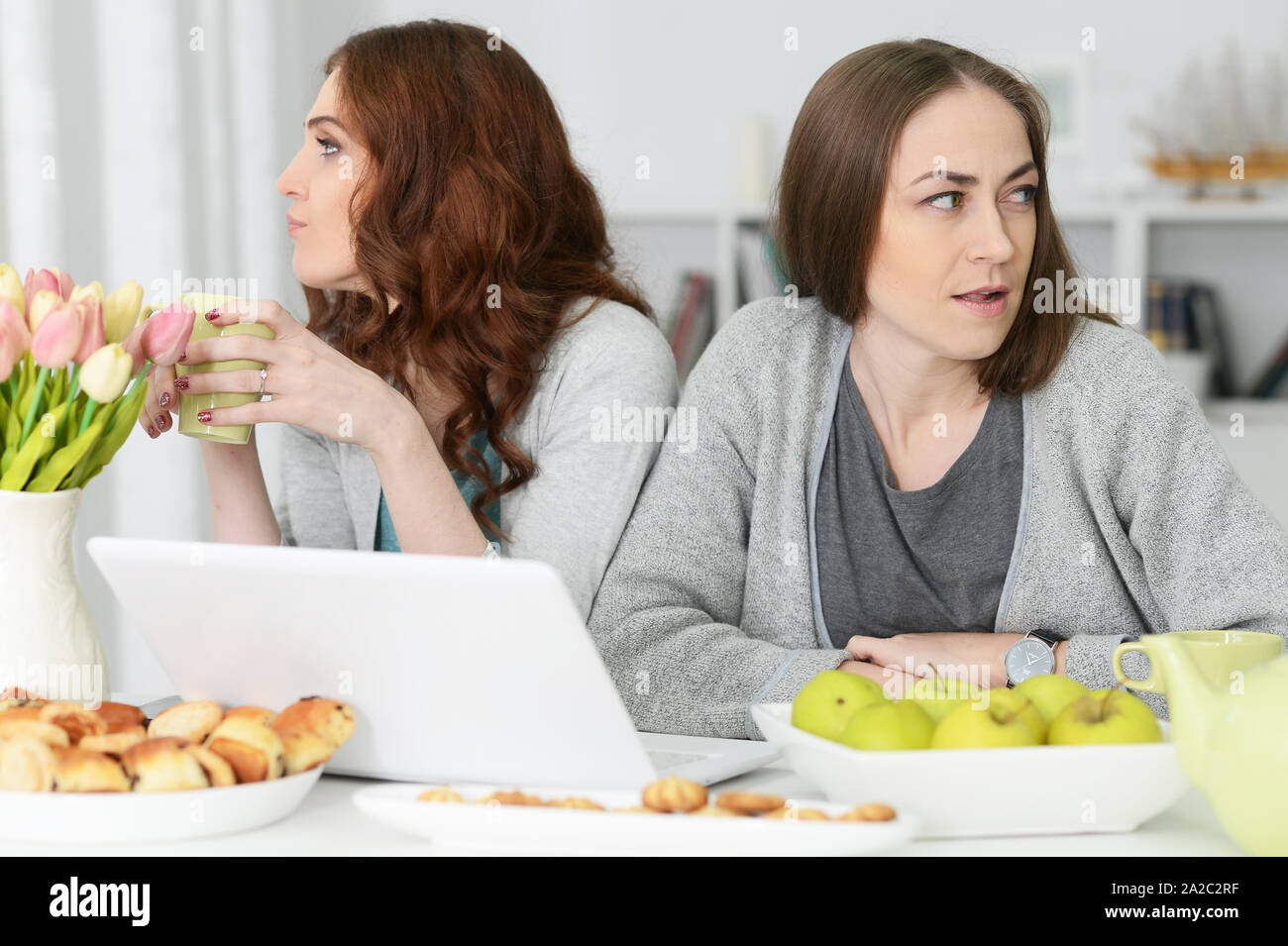Deux jeunes femmes en colère sitting at table Banque D'Images