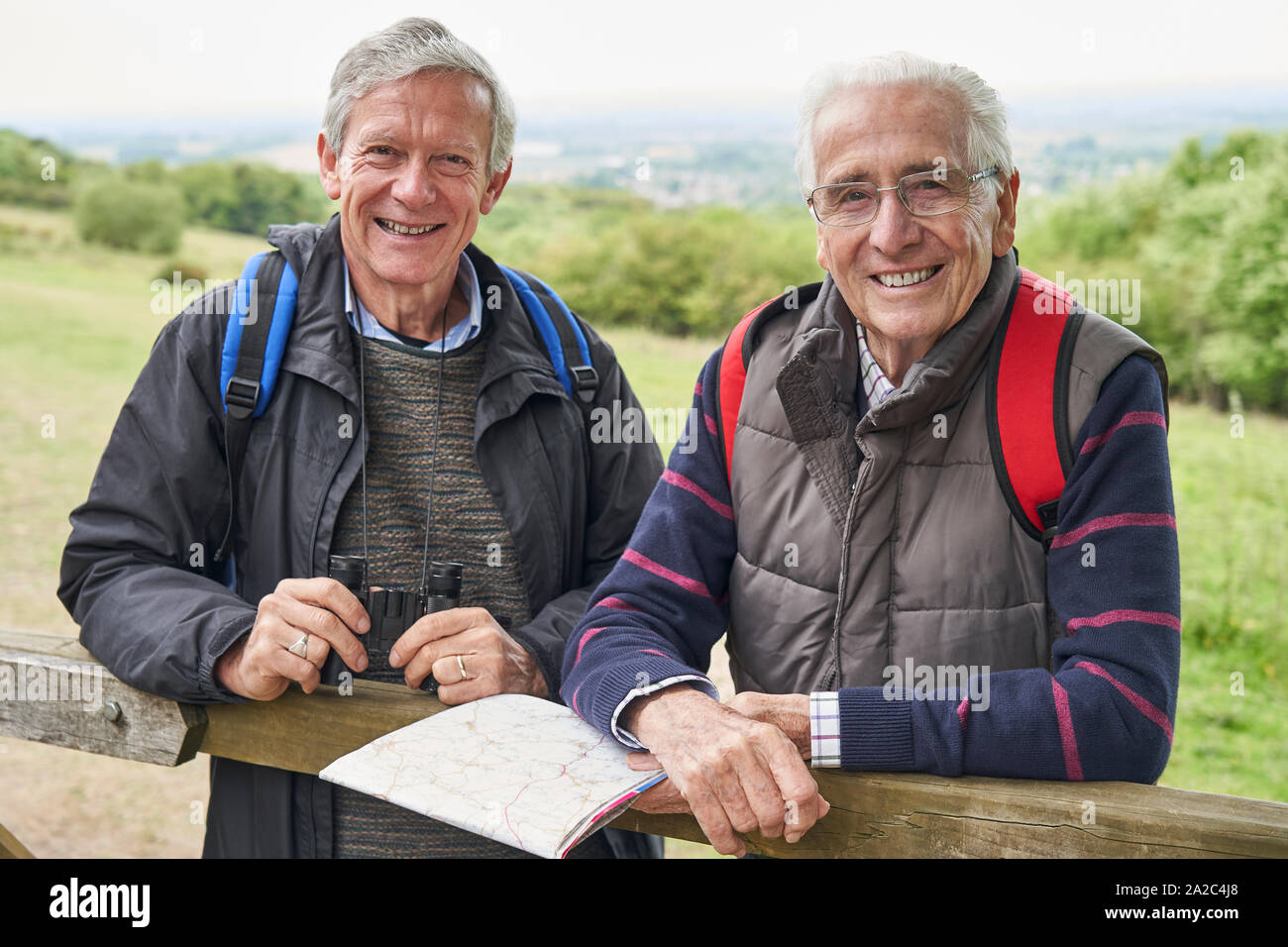 Portrait de deux amis masculins à la retraite sur la marche de vacances reposant sur la porte avec la carte Banque D'Images