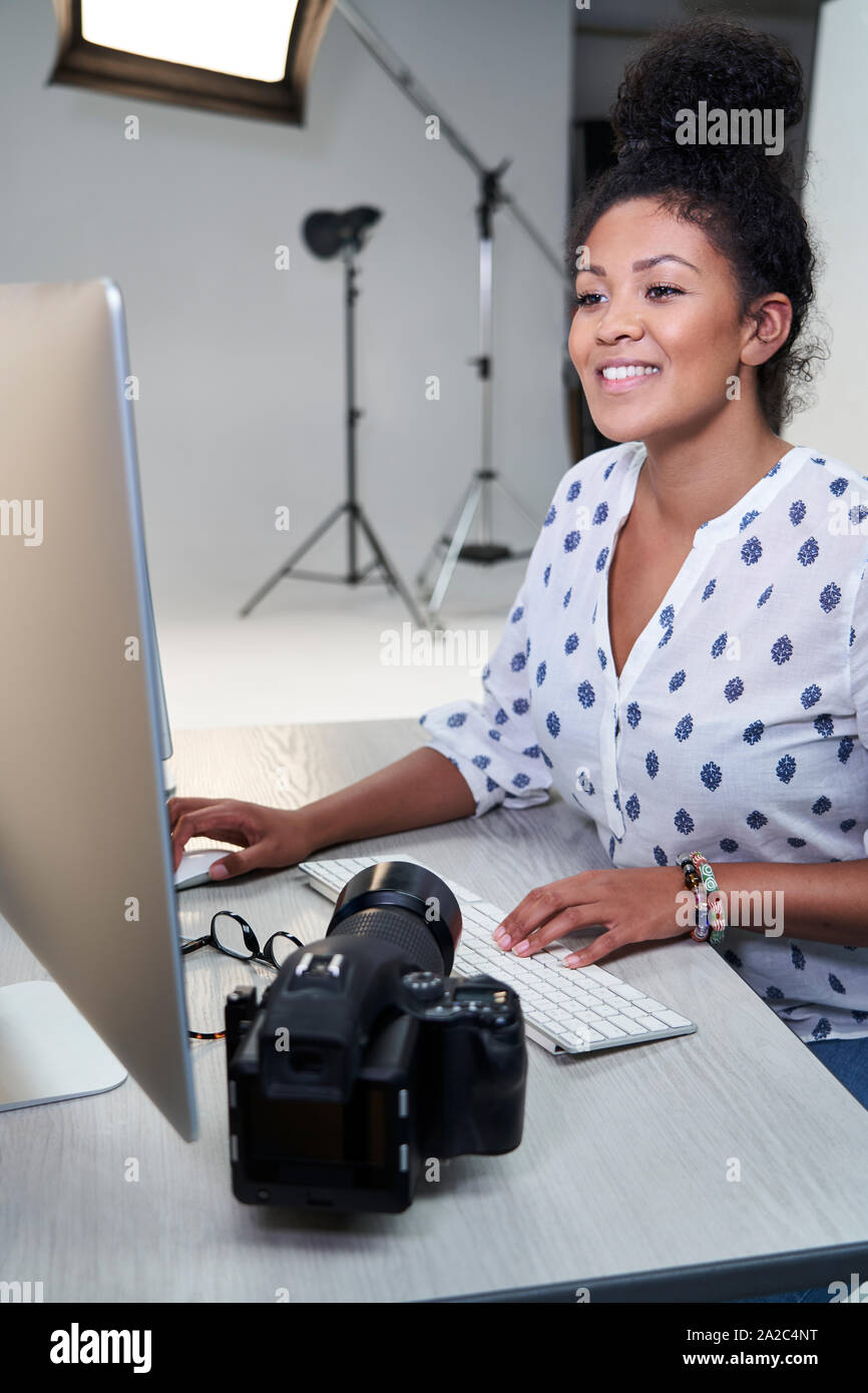Femme photographe en studio l'examen des images de la séance photo sur l'ordinateur Banque D'Images